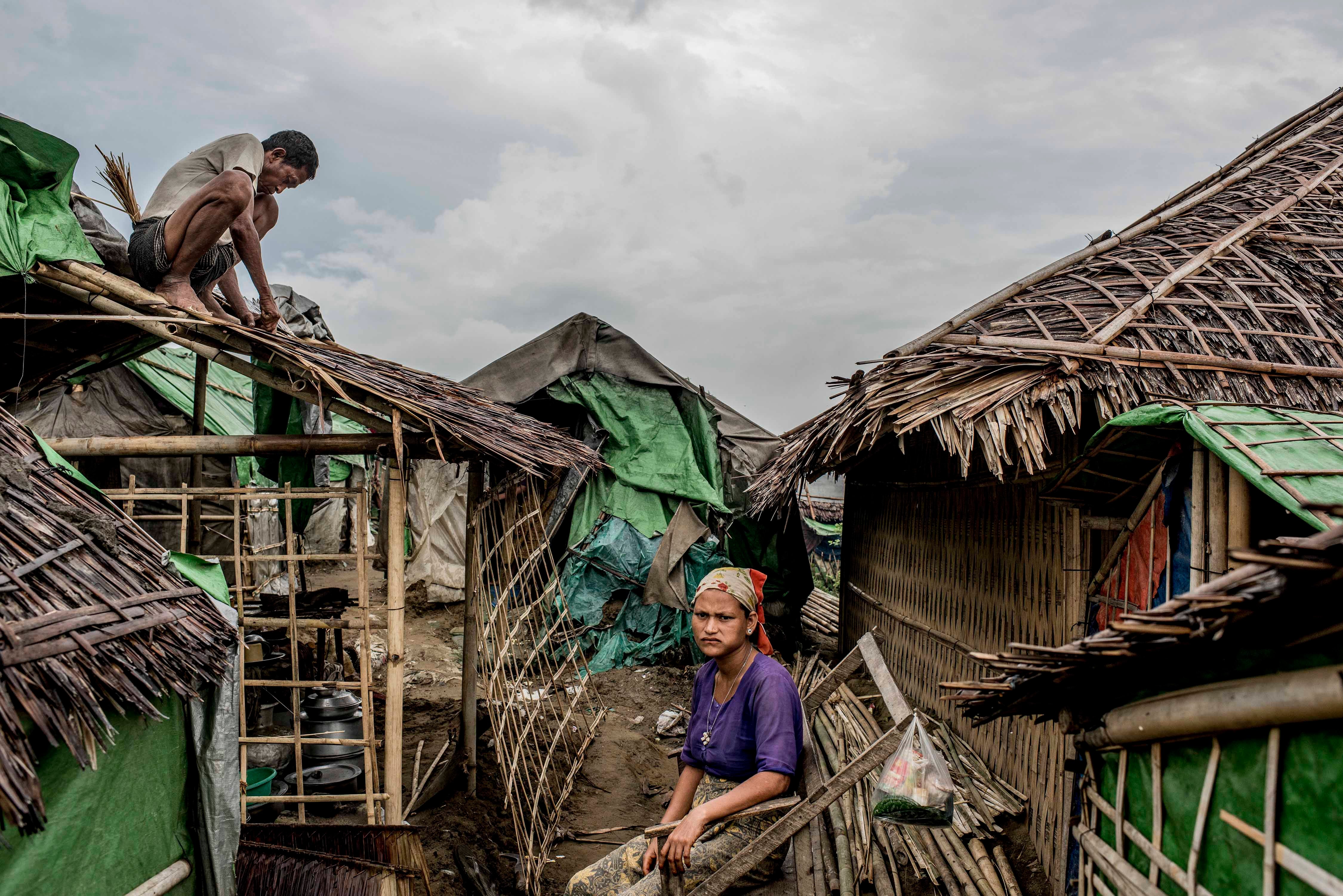 A Rohingya man fixes his roof