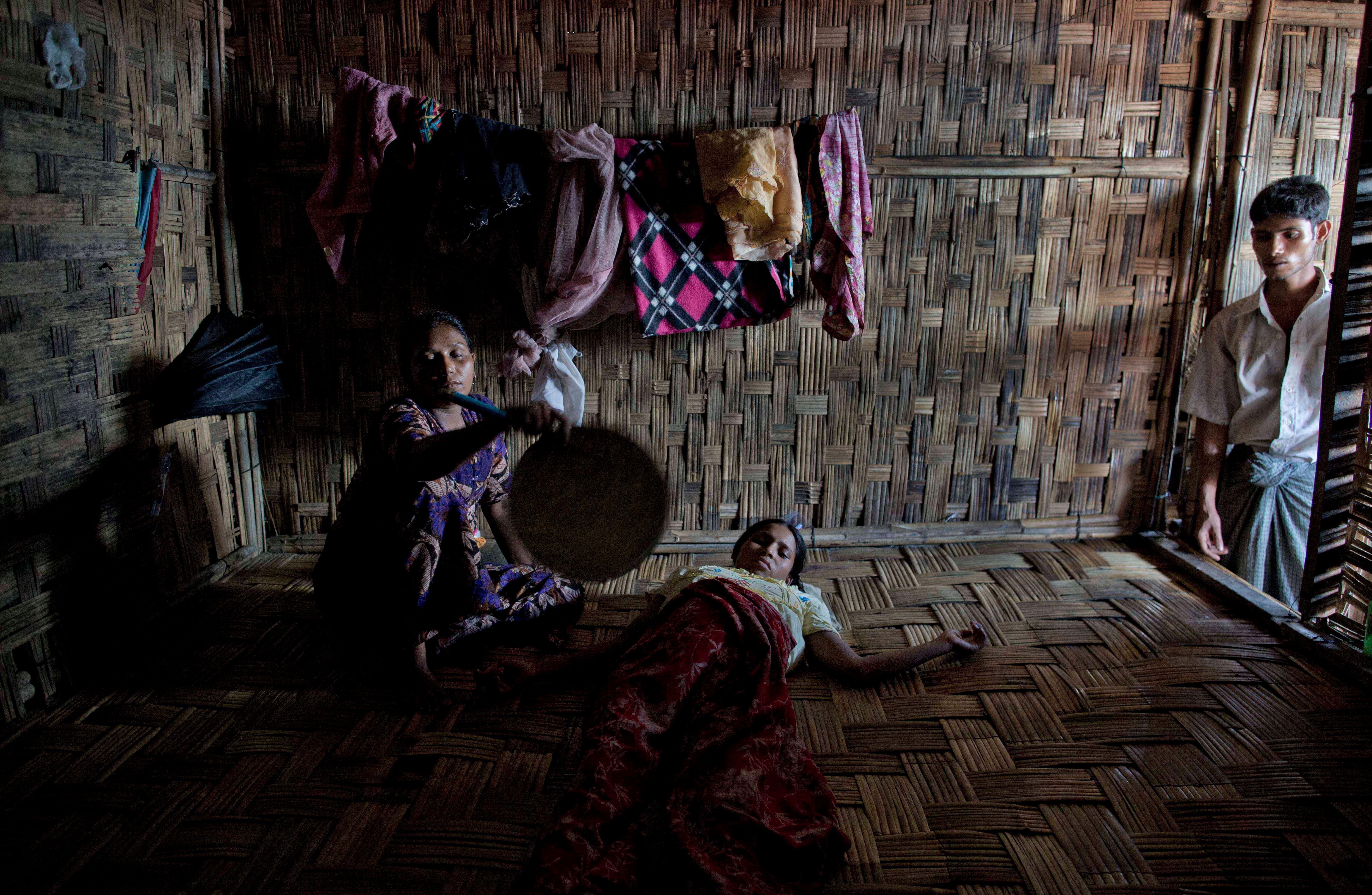 A Rohingya woman is fanned by a relative 