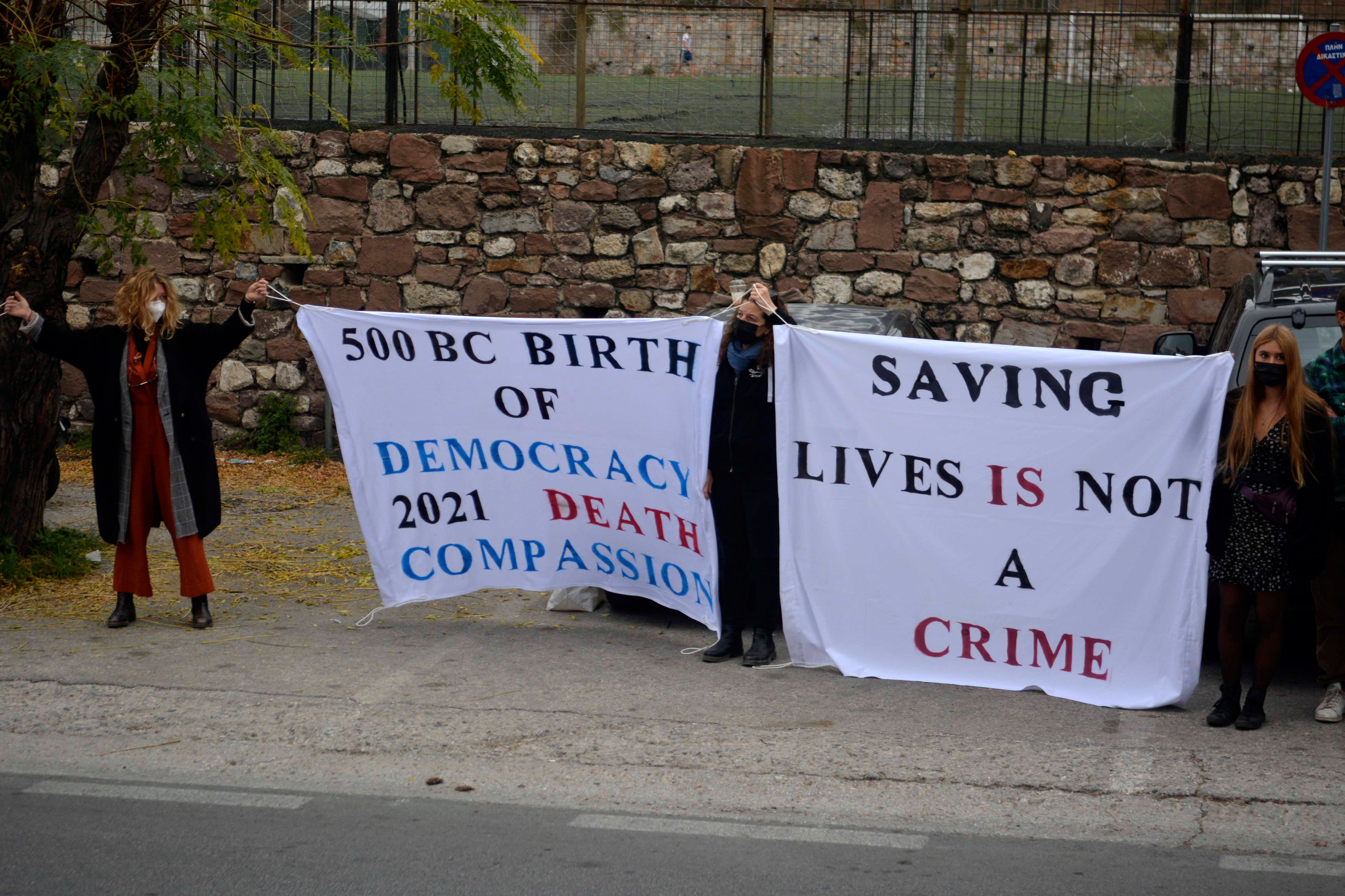 People hold banners outside a court