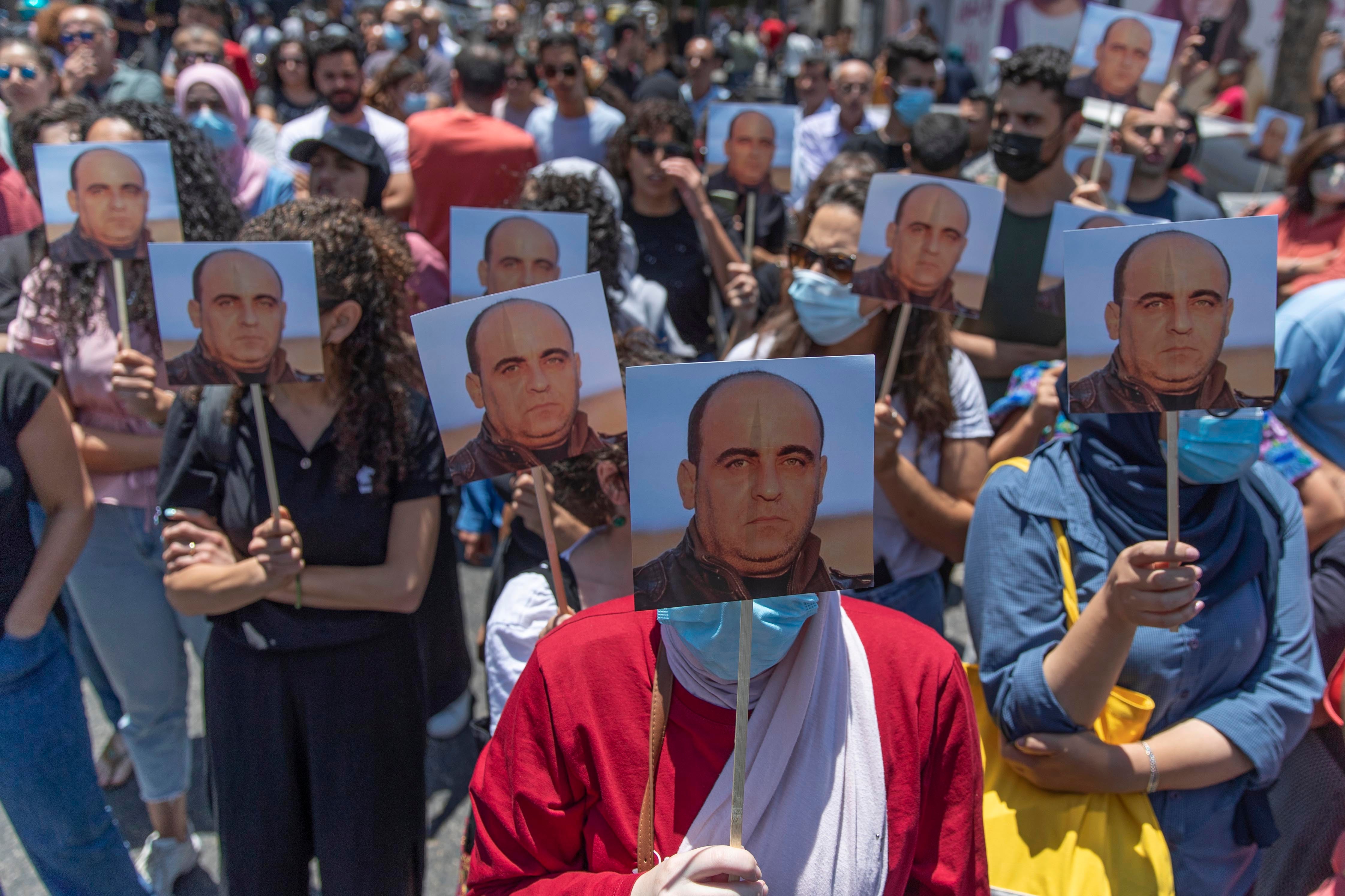 Demonstrators carry pictures of activist Nizar Banat during a protest in the West Bank city of Ramallah on the same day he was beaten to death in Palestinian Authority custody, Thursday, June 24, 2021.