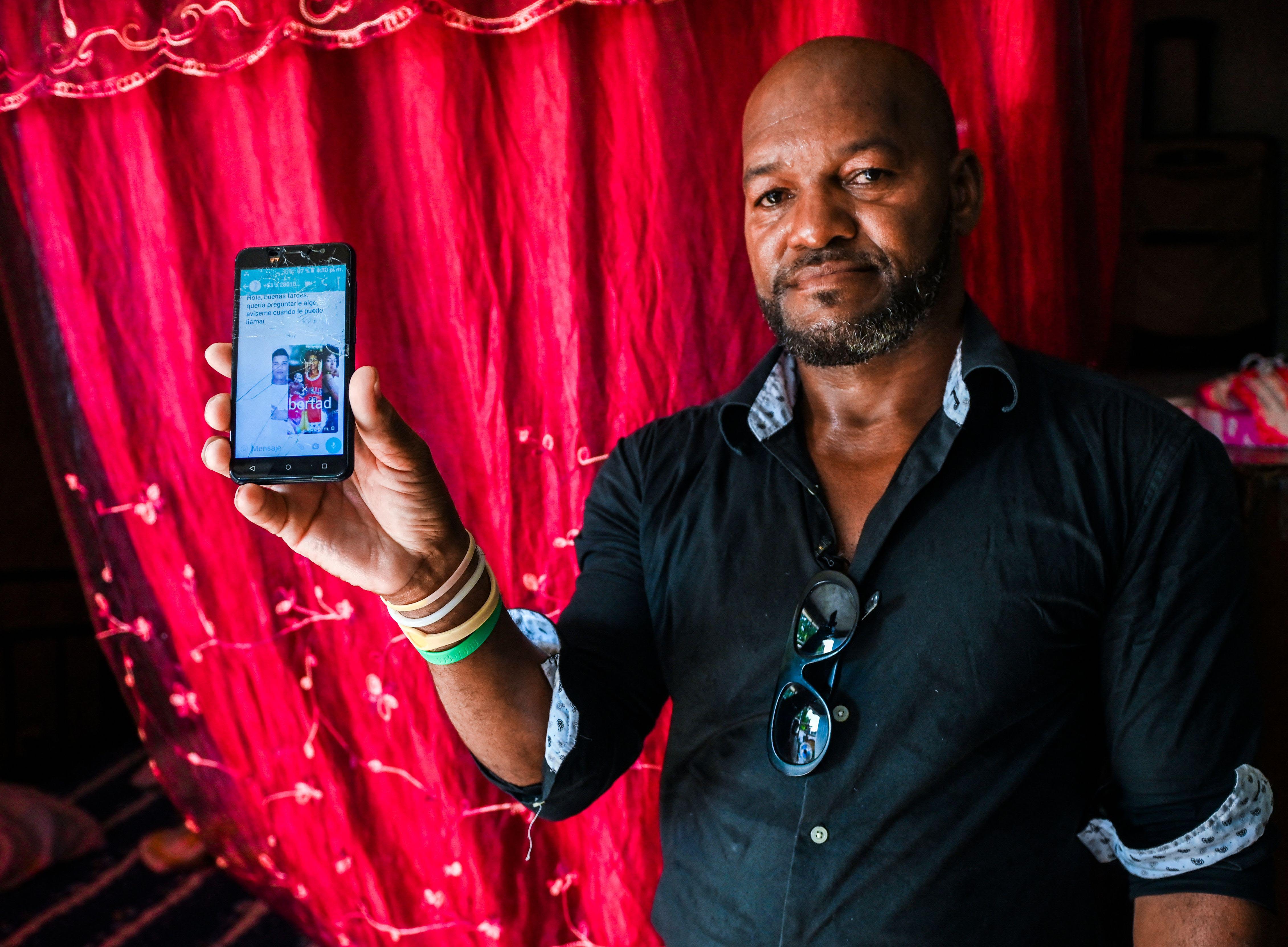 Emilio Roman, father of two young men and a daughter who were imprisoned and accused of participating in the July protests against the government, shows a picture of his children at their home in La Güinera neighborhood of Havana, March 29, 2022.