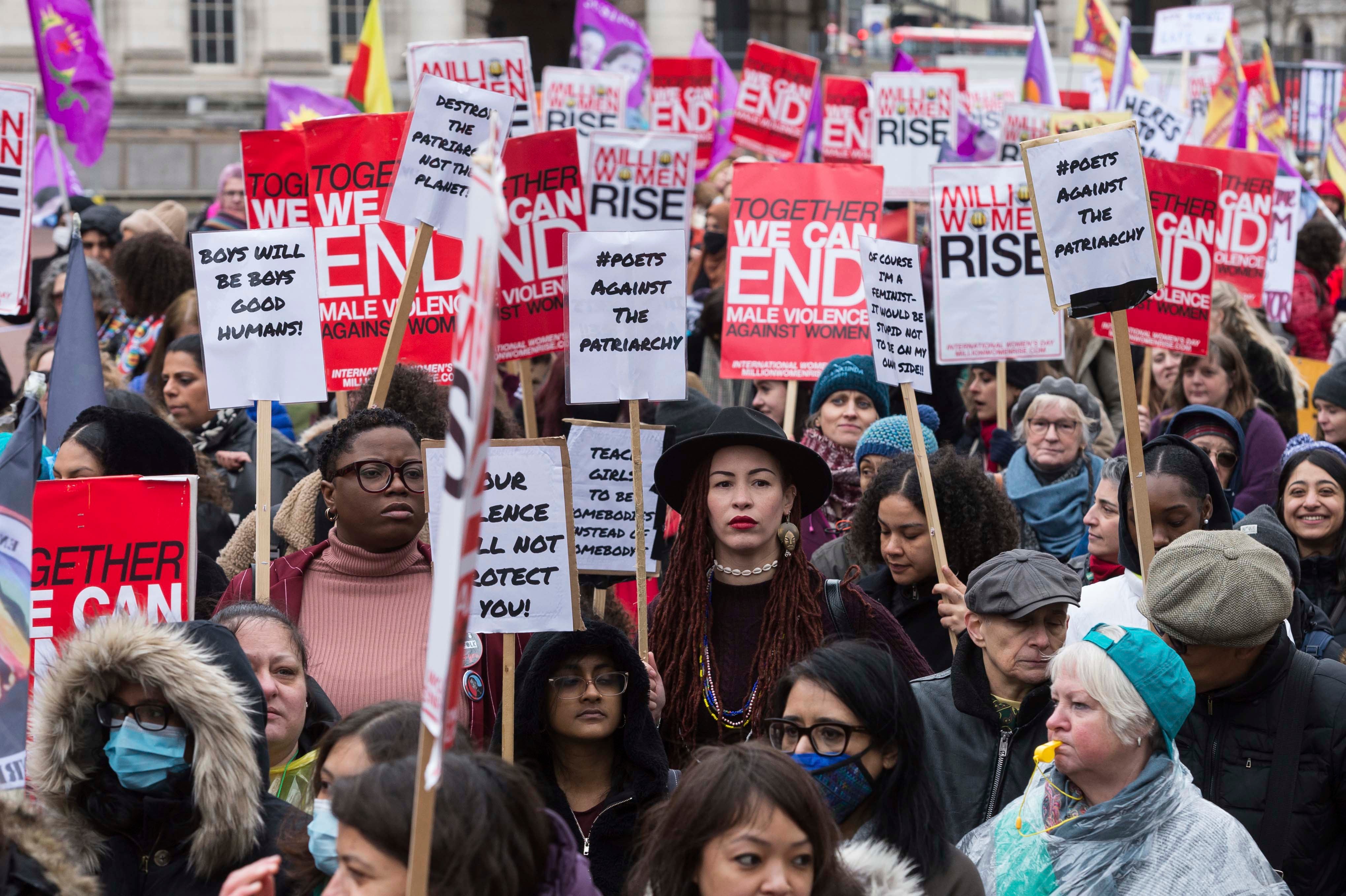 Women hold placards at the Million Women Rise march in London ahead of International Women's Day on March 05, 2022. 