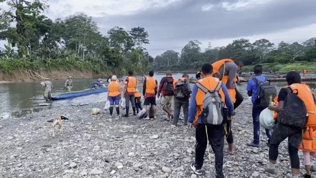 Migrantes esperan un bote que los lleve desde la comunidad indígena de Canaán Mebrillo a Puerto Limón, Panamá, después de una caminata de días por el Tapón del Darién, mayo de 2022.