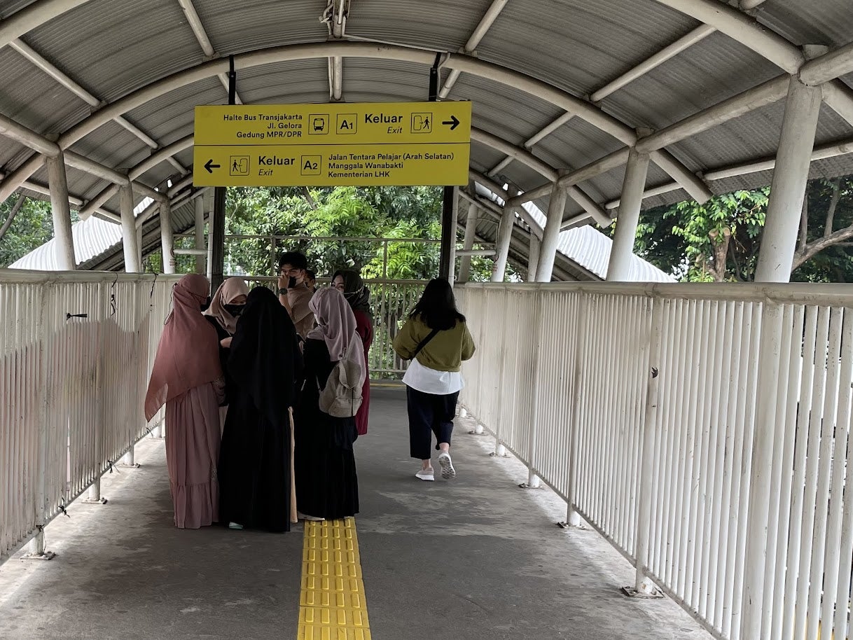 High school girls at a Jakarta train station commuting from an extracurricular school activity, wearing jilbabs and long dresses, June 2022.