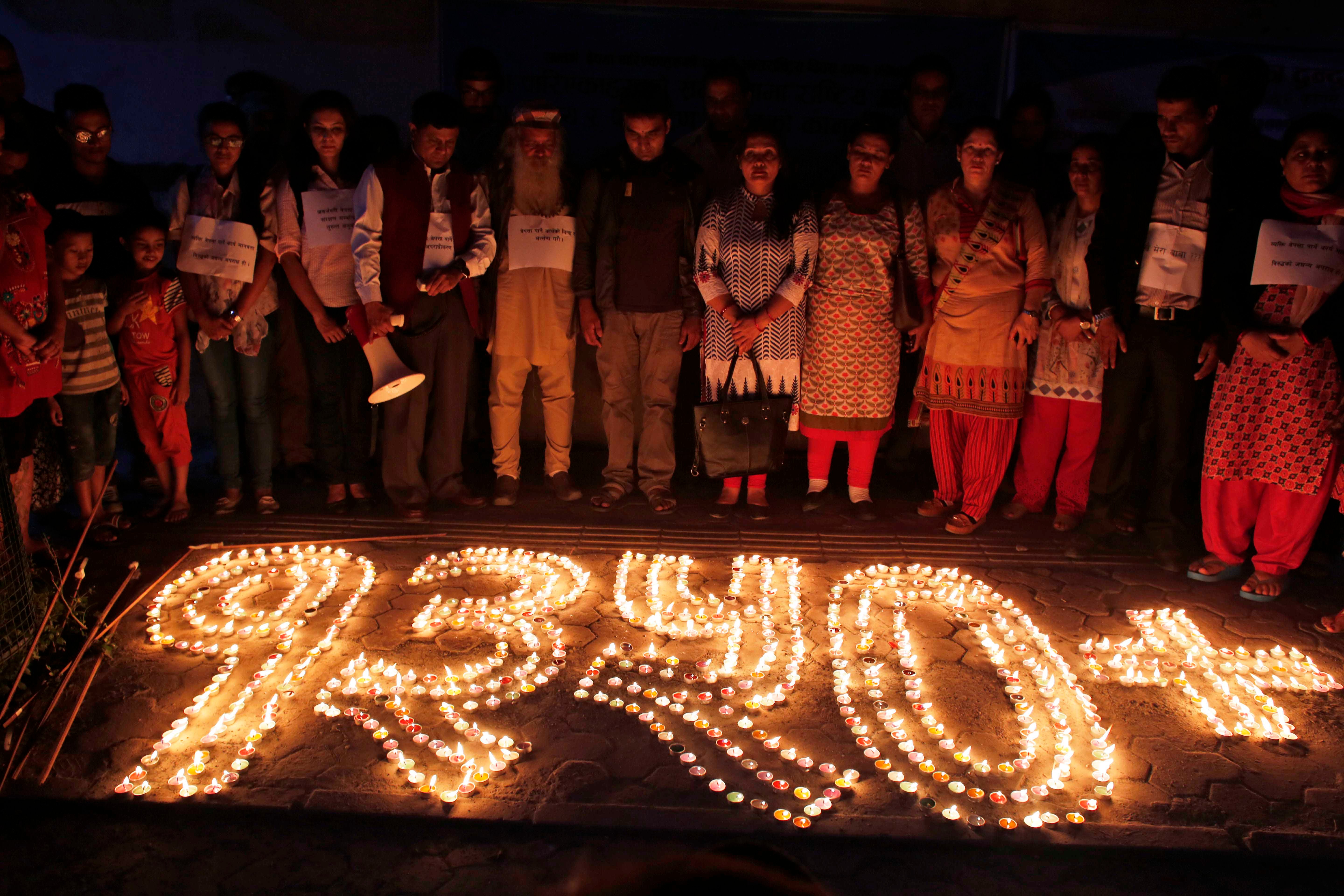 Nepalese human rights activists and relatives of disappeared persons, make a formation with lighted candles that reads 1350+ (referring to the number of victims) at an event to mark the International Day of the Disappeared in Kathmandu, Nepal, August 30, 2017.