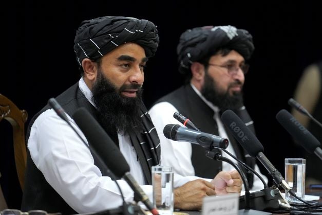 Zabiullah Mujahid, left, the spokesman for the Taliban government, speaks during a press conference