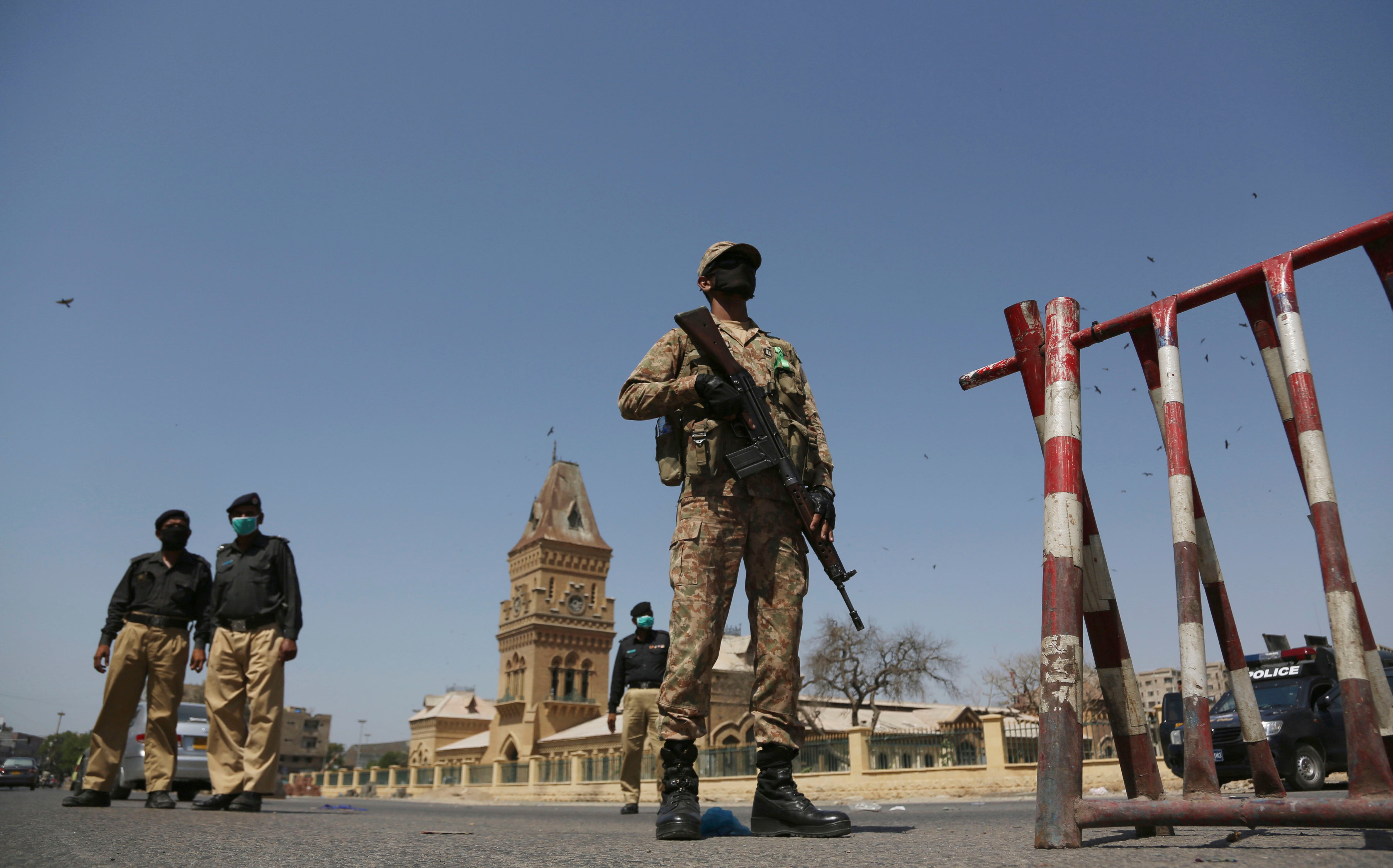 Soldiers and police stand guard during a lockdown to help stop the spread of the coronavirus, Karachi, Pakistan, March 3, 2020. 
