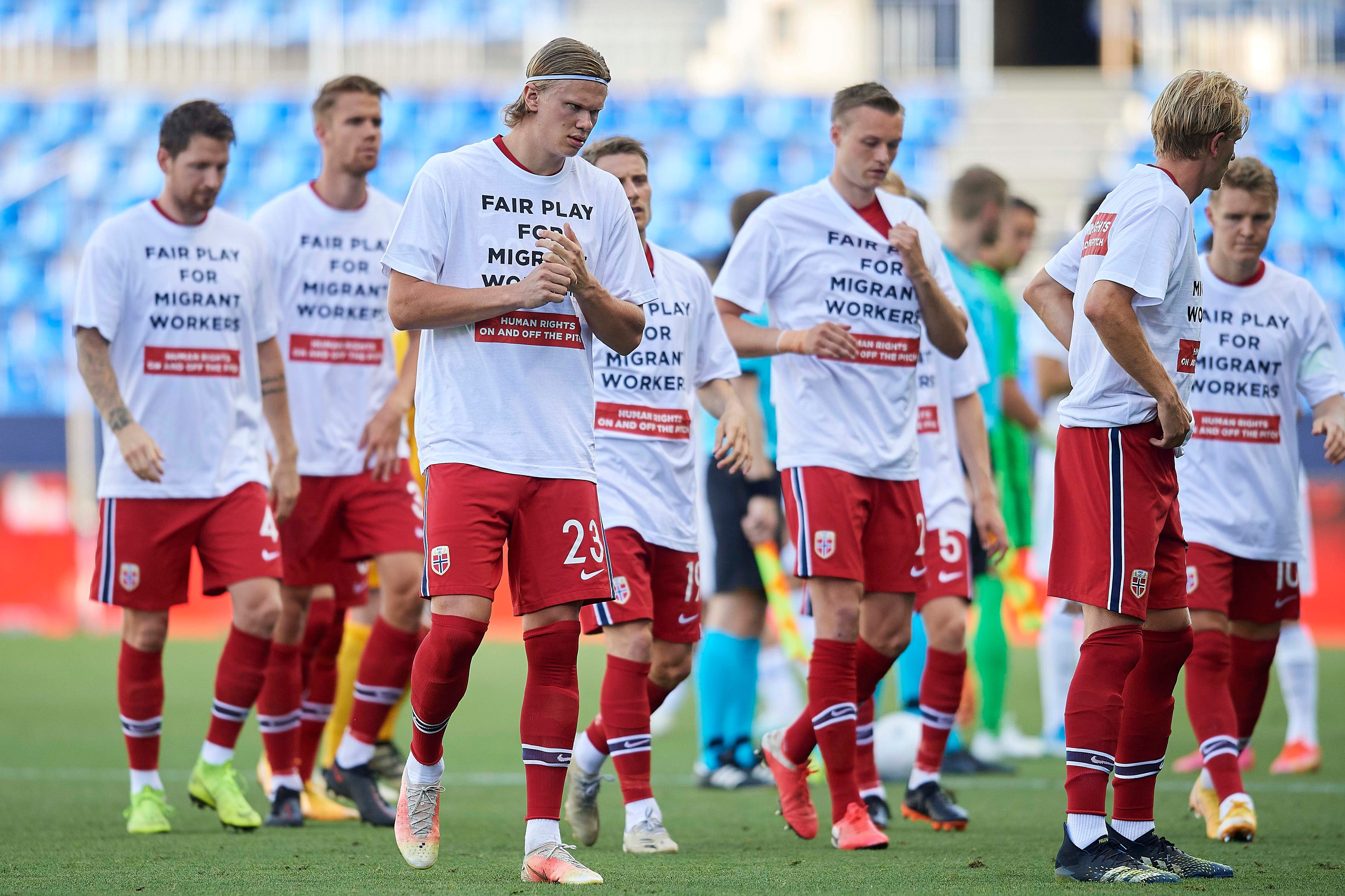 Members of a football team wear t-shirts calling for human rights for migrant workers 