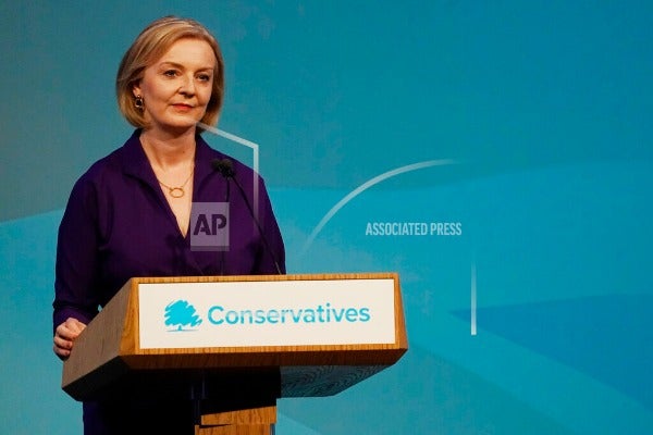 Liz Truss standing in front of podium