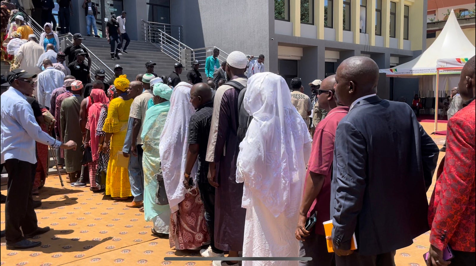 Des membres des familles de victimes du massacre commis en 2009 dans un stade de Conakry (Guinée), ainsi que des personnes y ayant survécu, faisaient la queue pour entrer dans un tribunal de Conakry le 28 septembre 2022, au premier jour du procès d’individus accusés d'être responsables de ce massacre.