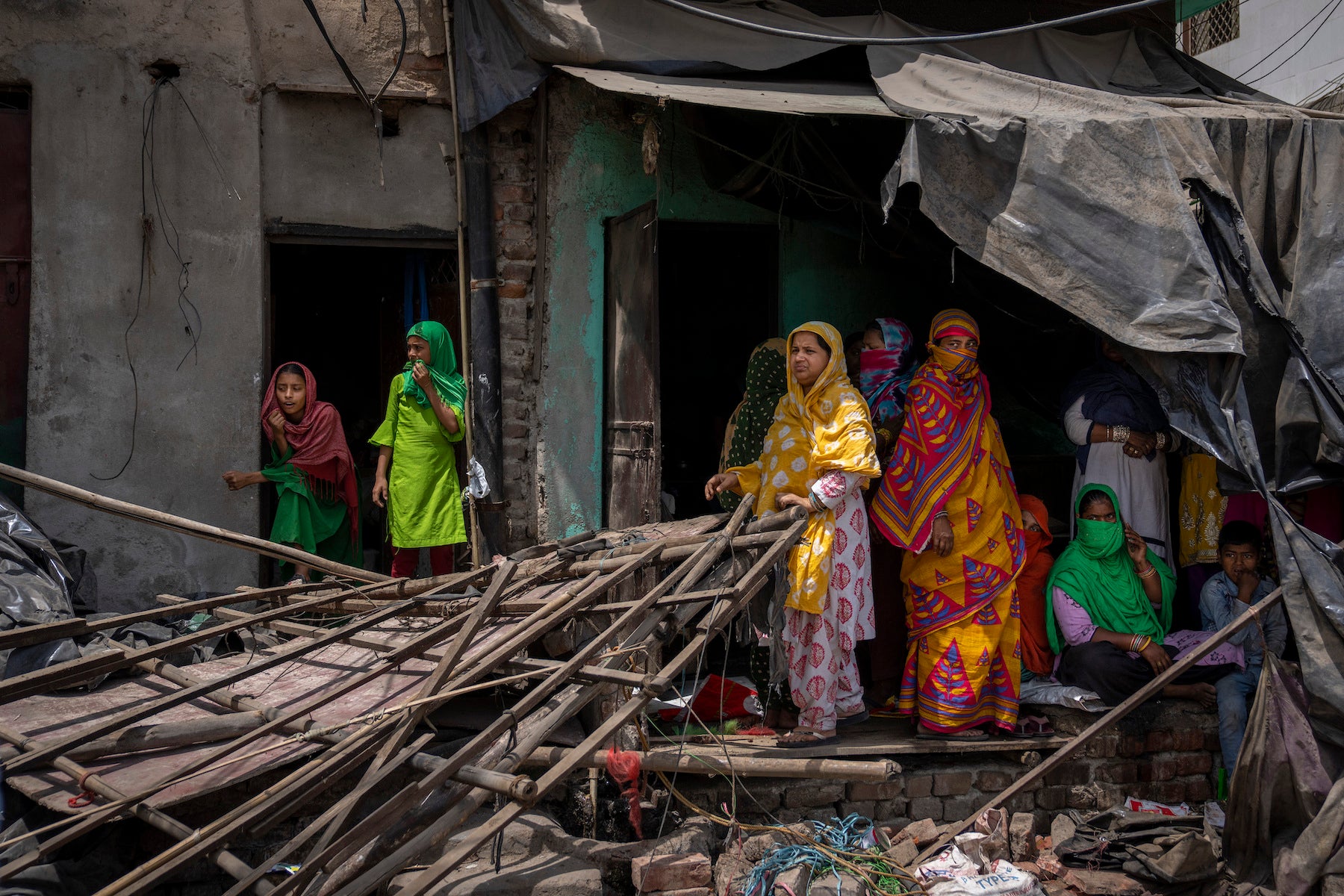 omen stand near the rubble of a shop after authorities demolished a number of Muslim-owned businesses in New Delhi. 