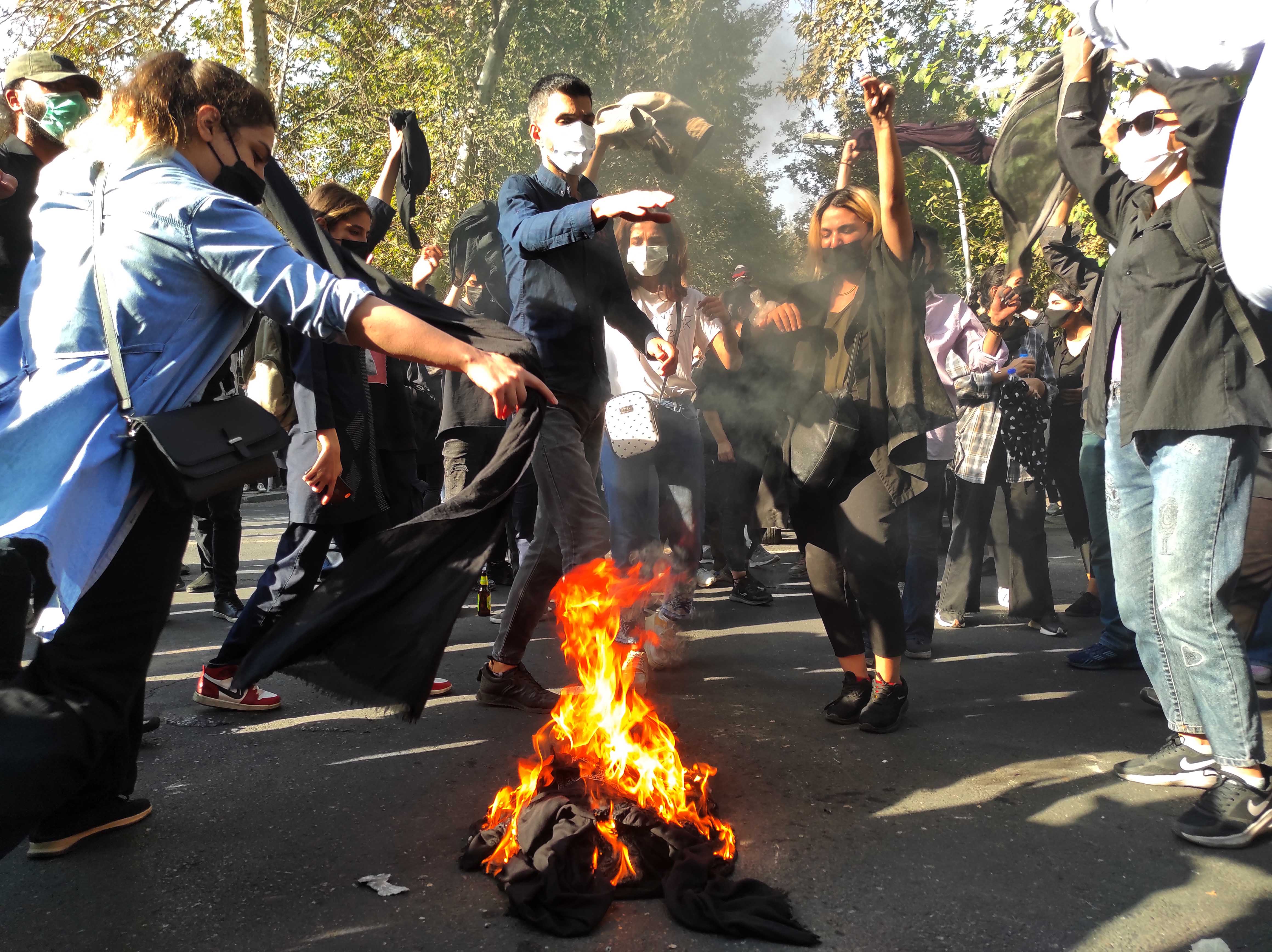 Iranian demonstrators march down a street in Tehran, October 1, 2022. 