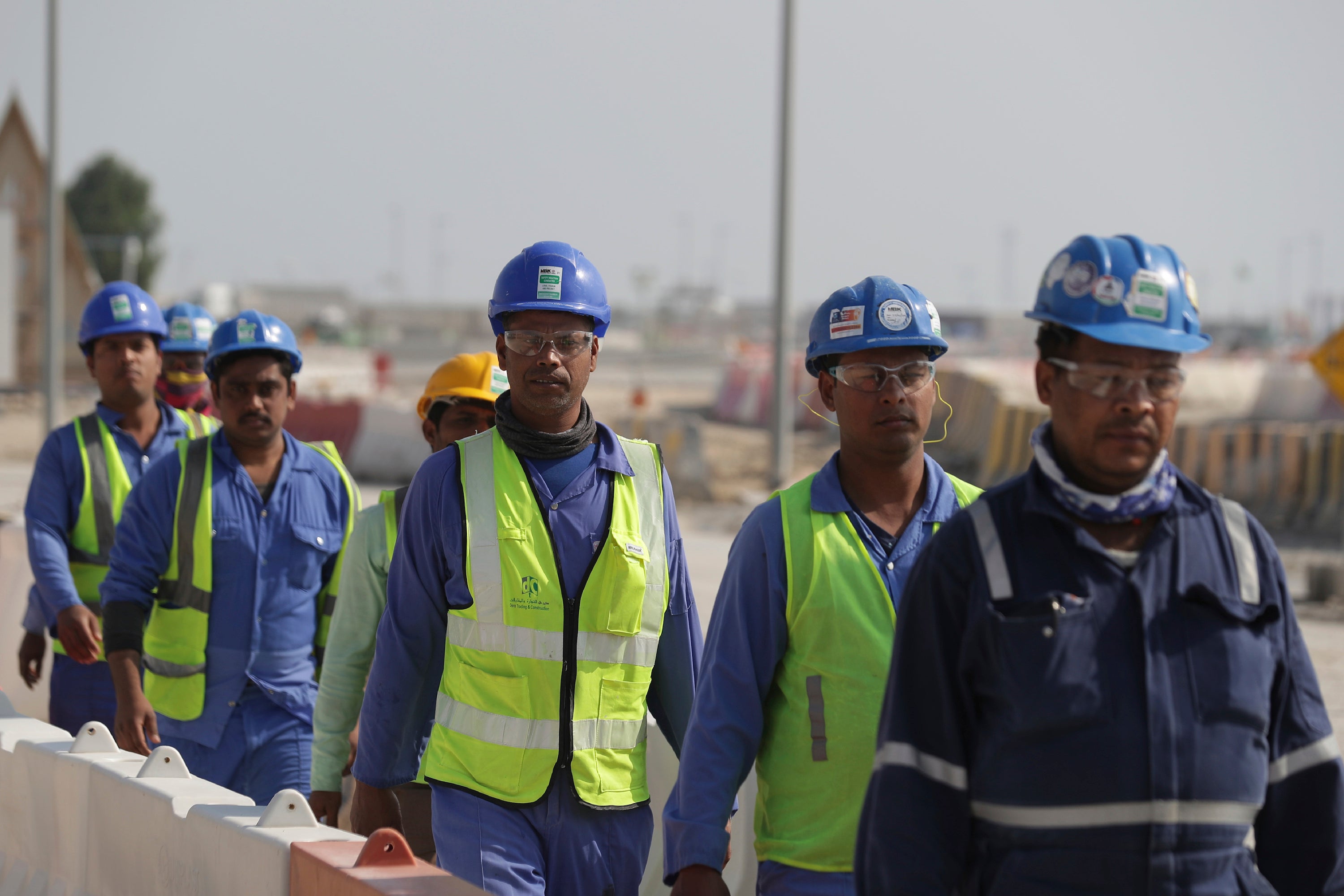 Des ouvriers marchent vers le stade de Lusail, l'un des stades de la Coupe du monde 2022, à Lusail, au Qatar, en décembre 2019.