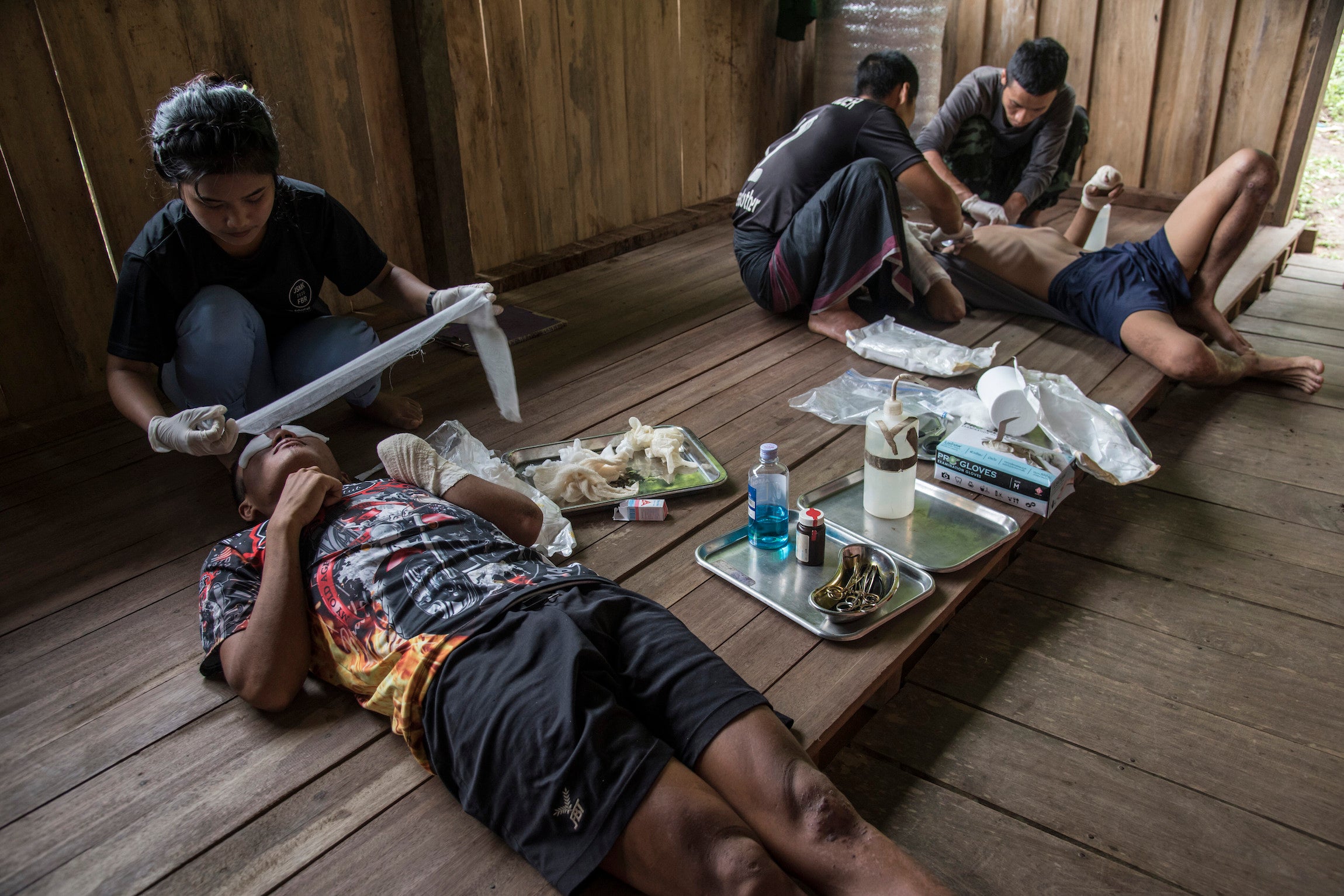 Volunteer medics helping men injured by landmines in Myanmar. 