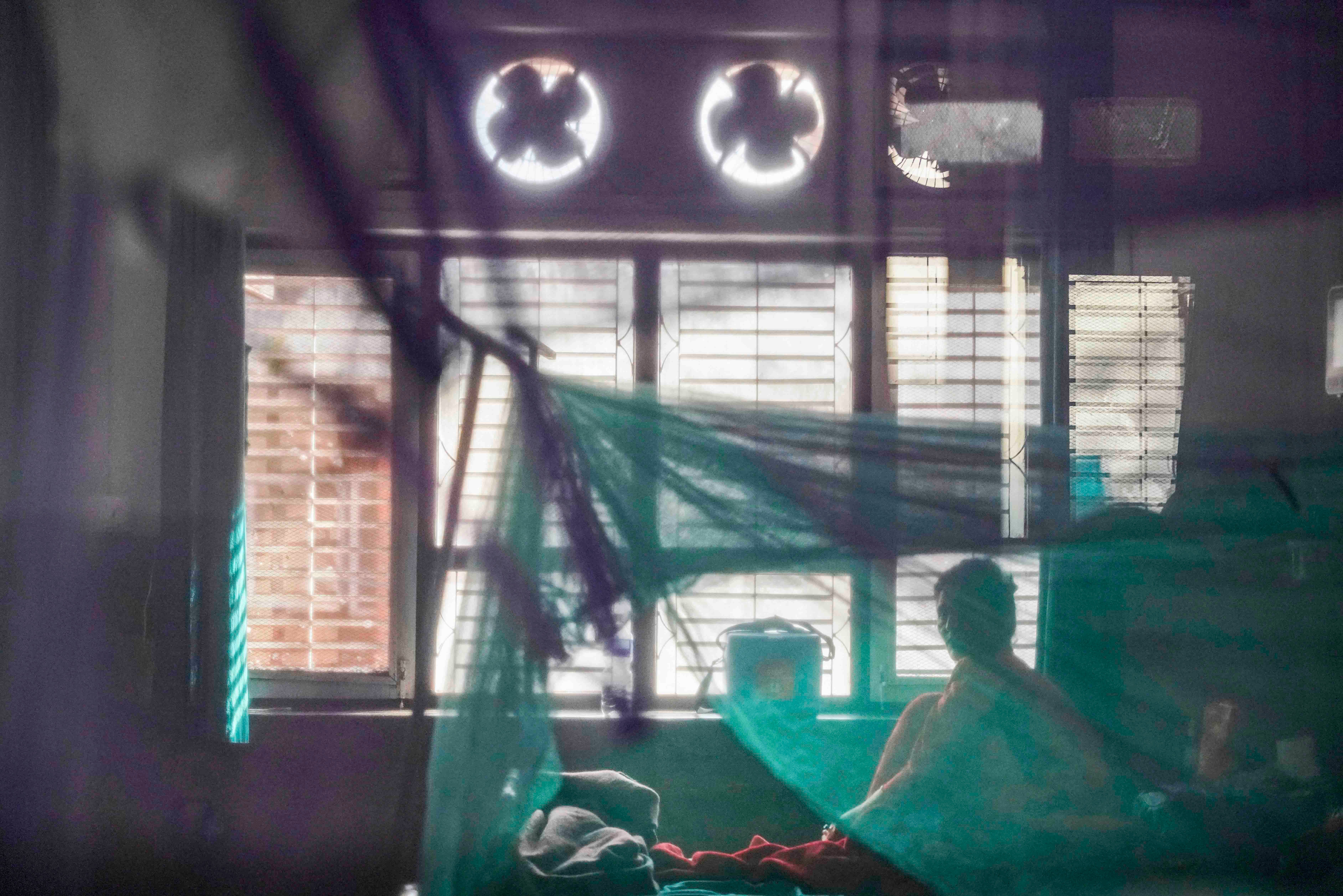 A patient sits on her bed after being admitted with dengue at Sukraraj Tropical and Infectious Disease Hospital in Kathmandu.