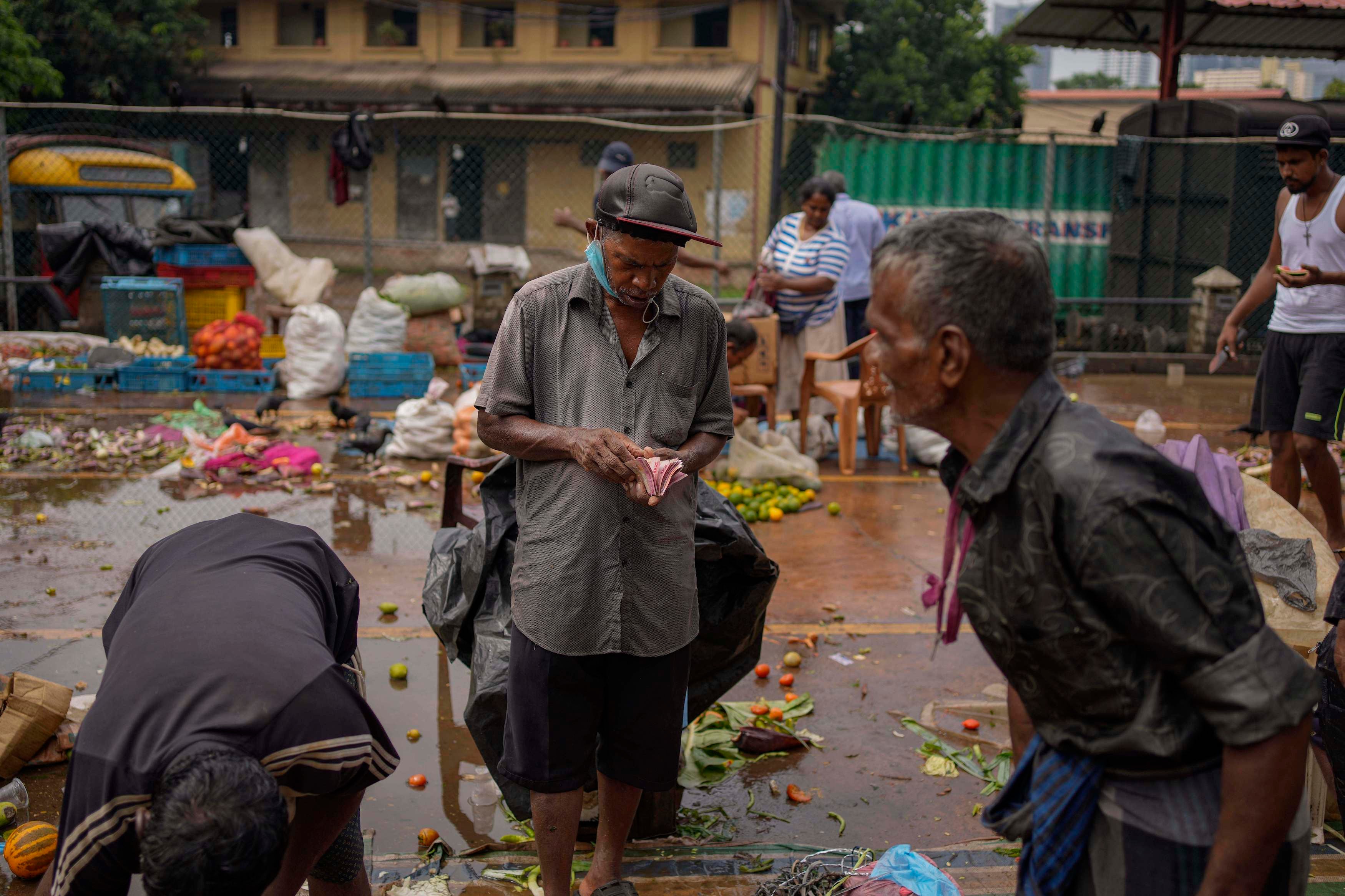 A man counts money at a marketplace in Colombo, Sri Lanka