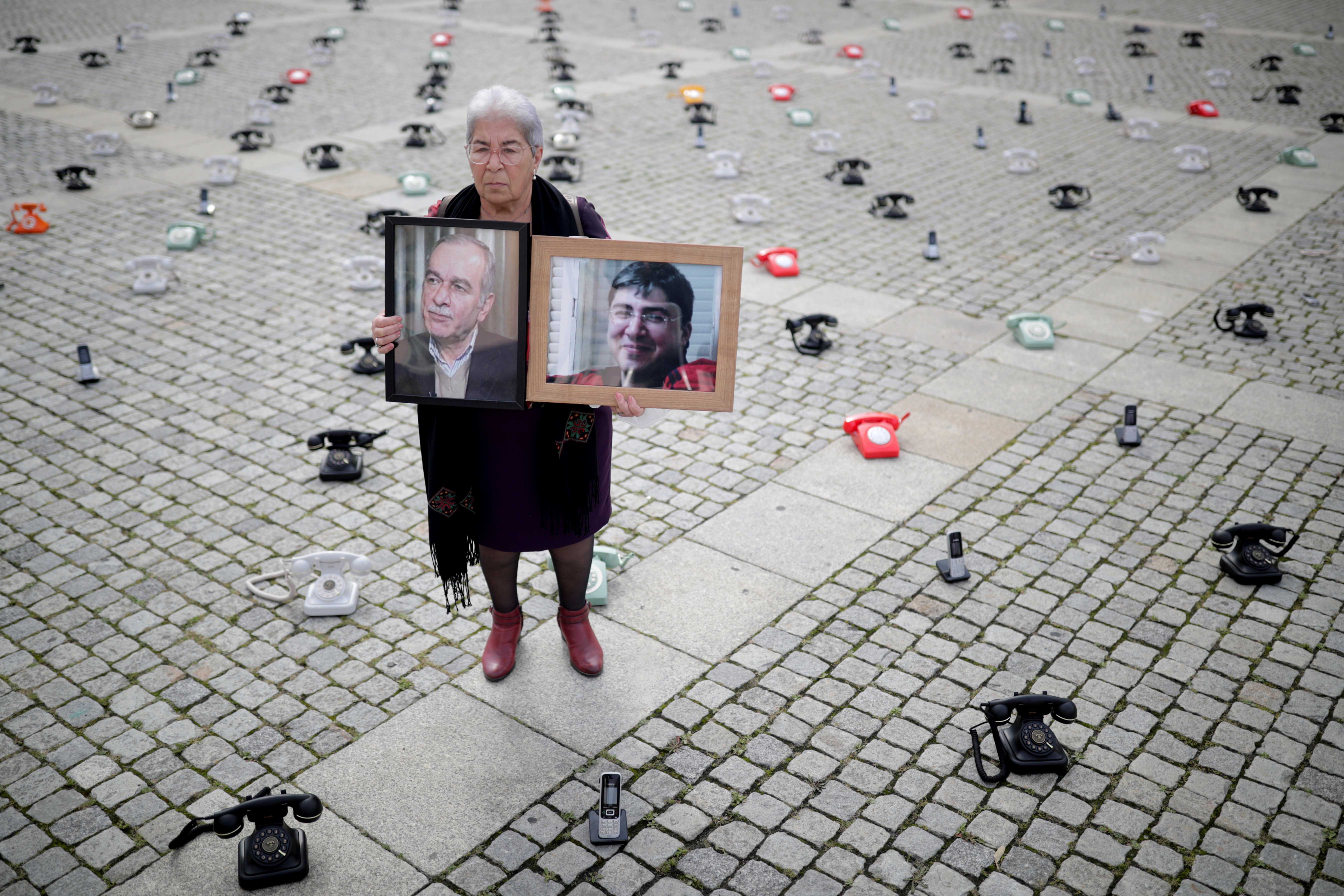 Fadwa Mahmoud holds portraits of her son and husband, who disappeared in Syria in 2012, in Berlin, Germany.