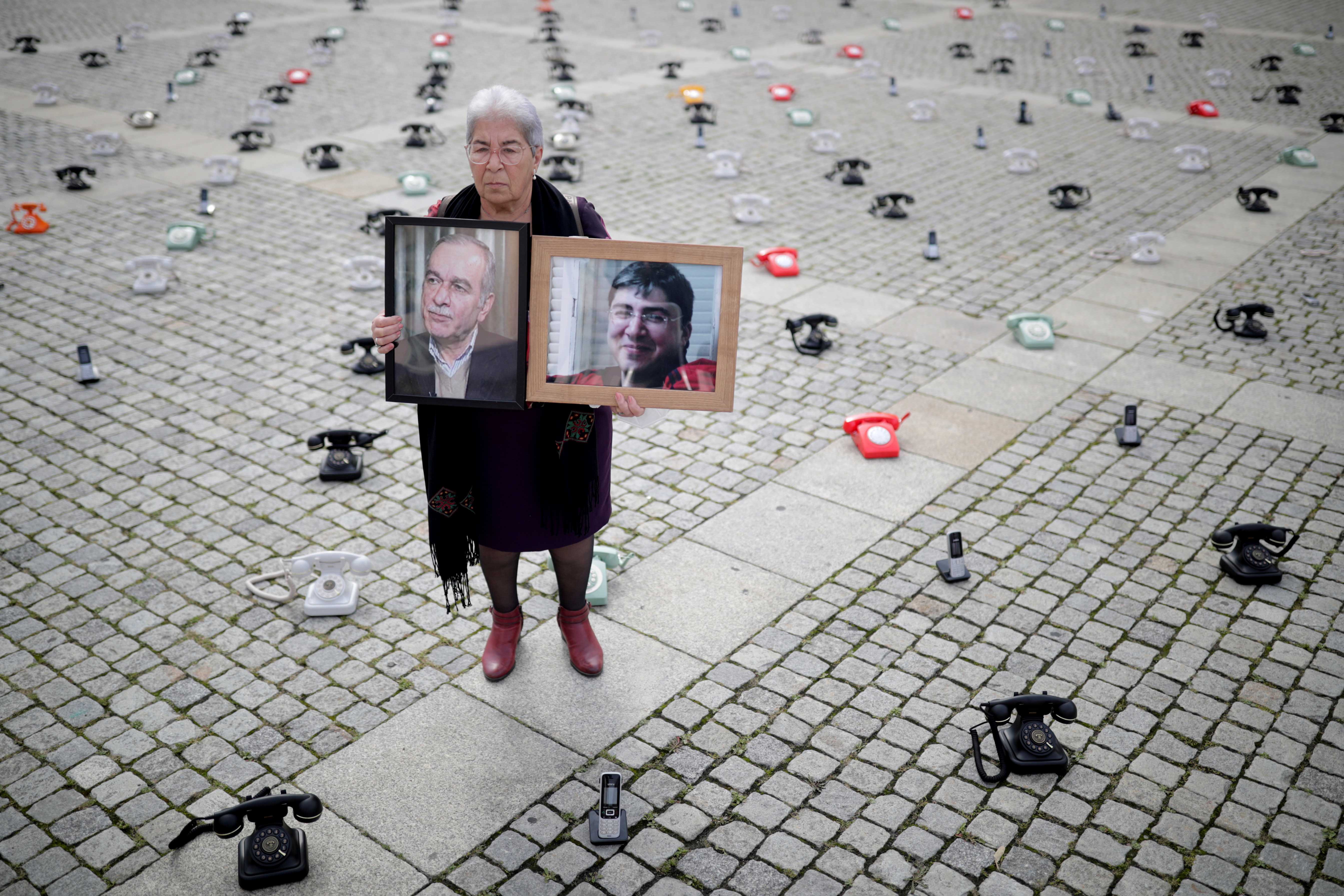 Fadwa Mahmoud sostiene unos retratos de su hijo y su marido, desaparecidos en Siria en 2012, en Berlín, Alemania. 