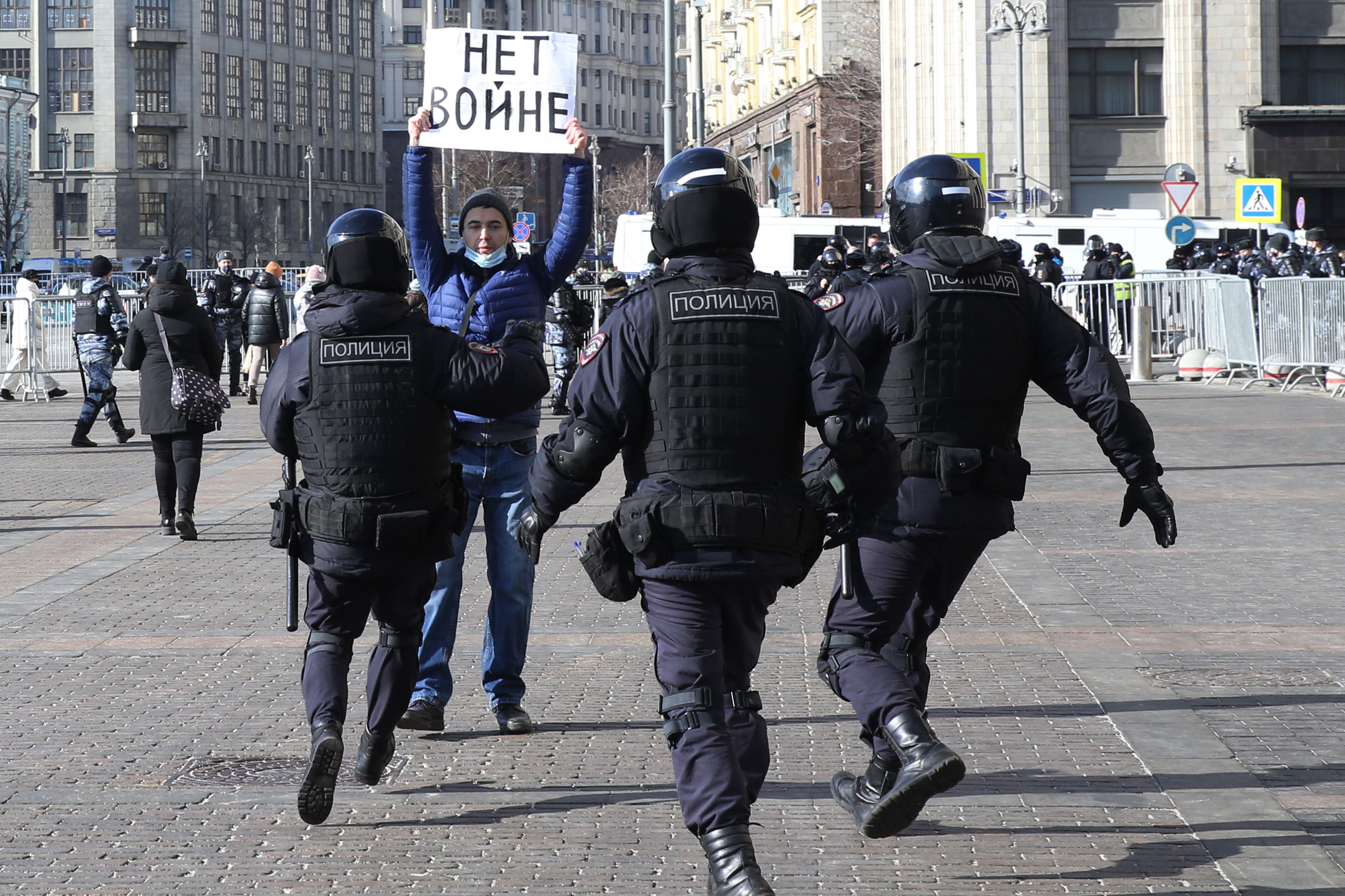 Polizeibeamte nehmen einen Mann mit einem Plakat mit der Aufschrift "Kein Krieg" fest während einer nicht genehmigten Demonstration am 13. März 2022 auf dem Manezhnaya-Platz vor dem Kreml in Moskau, Russland. 