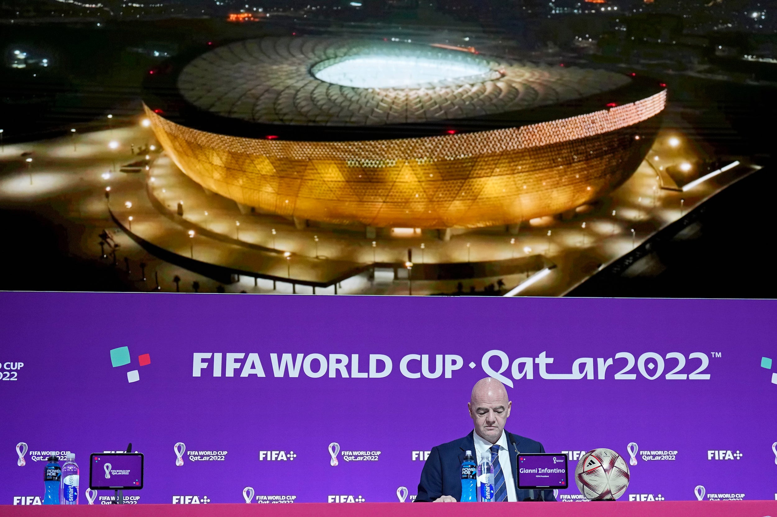 Le président de la FIFA, Gianni Infantino, assis devant une photo géante du Stade de Lusail, lors d’une conférence de presse tenue à Doha le 16 décembre 2022, deux jours avant la finale de la Coupe du monde de football au Qatar.