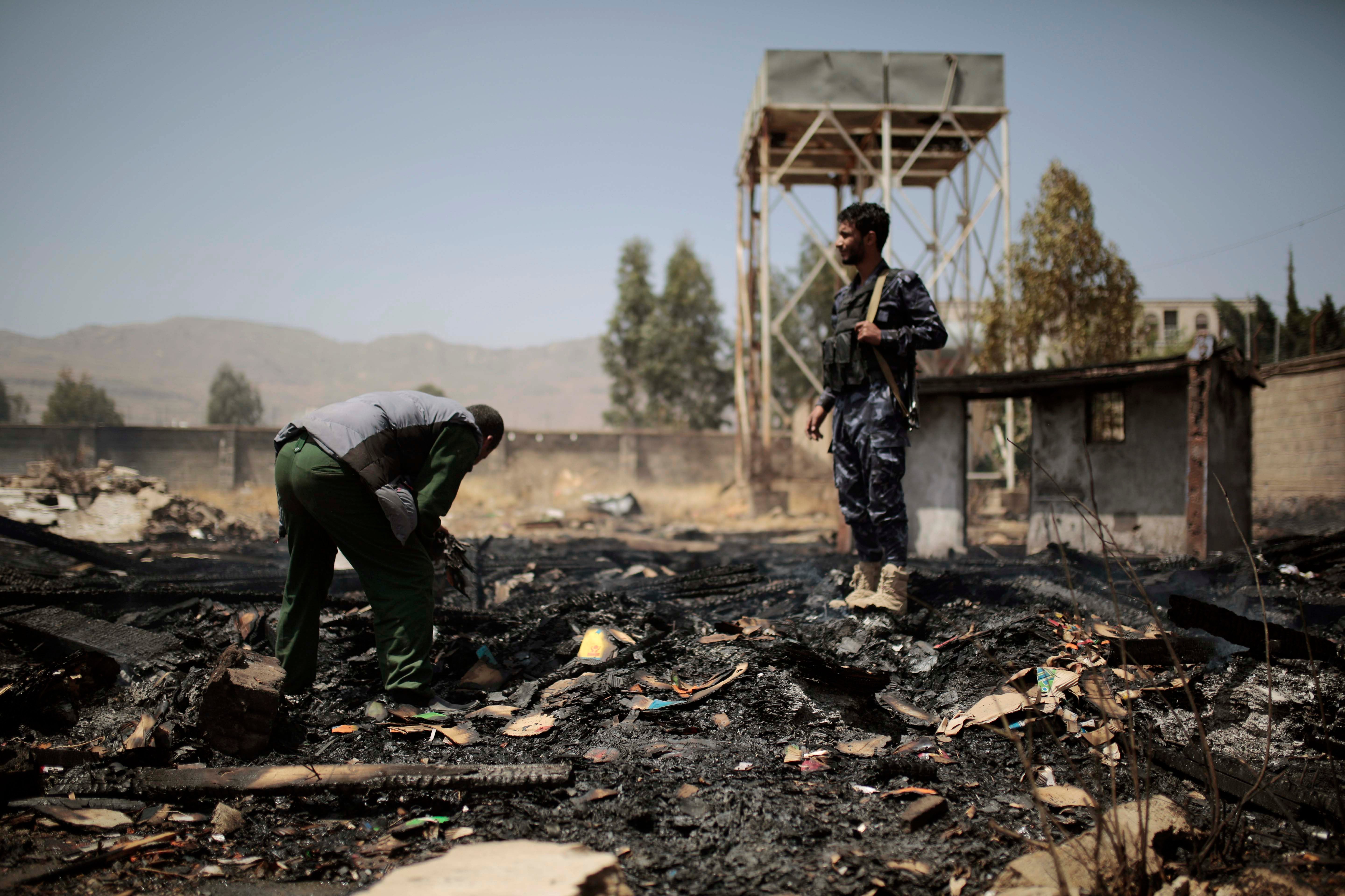 Yemeni police inspect a site of Saudi-led airstrikes that hit two houses in Sanaa, Yemen, March 26, 2022. 