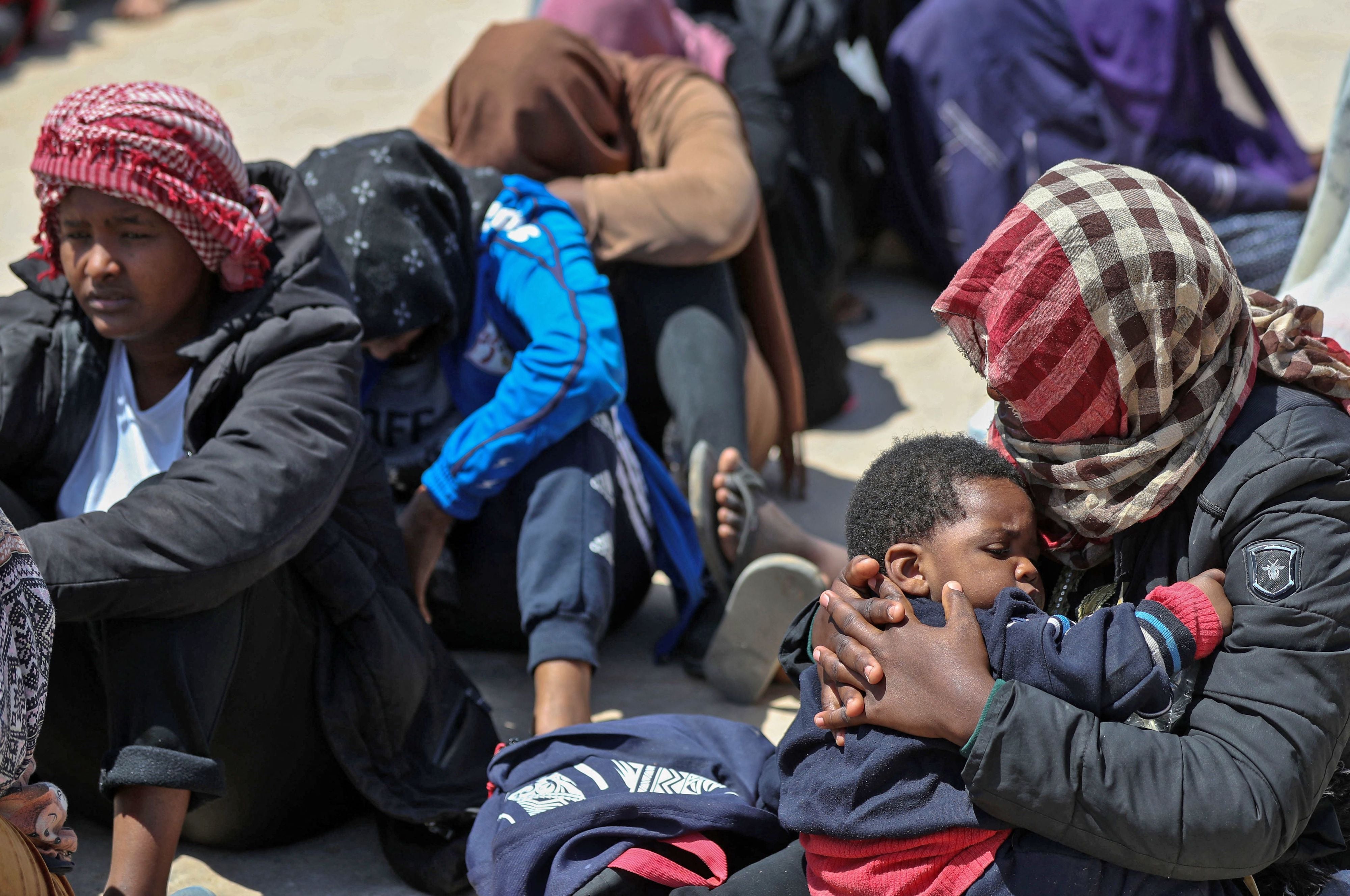 Ces migrants africains cherchant à se rendre en UE se trouvaient sur un bateau en mer Méditerranée, près de la côte libyenne, avant d’être interceptés par des garde-côtes libyens. Ils étaient assis par terre, avant leur transfert dans un centre de détention à Surman, dans le nord-ouest de Libye, le 12 mai 2022.
