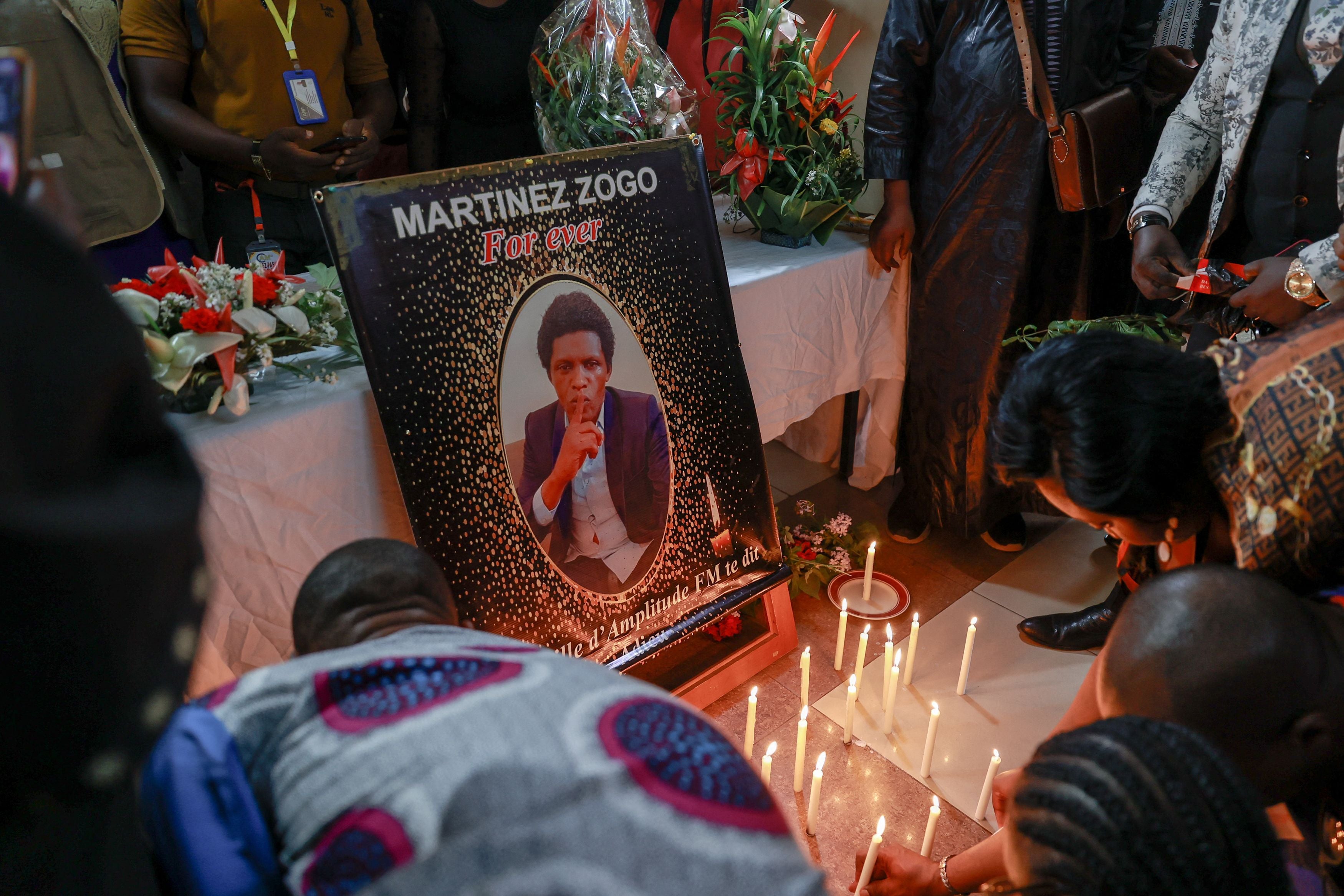 Mourners place candles in a room of Radio Amplitude FM where a portrait of journalist Martinez Zogo has been placed to pay tribute to him in Elig Essono district in Yaounde, Cameroon, on January 23, 2023. © DANIEL BELOUMOU OLOMO/AFP via Getty Images