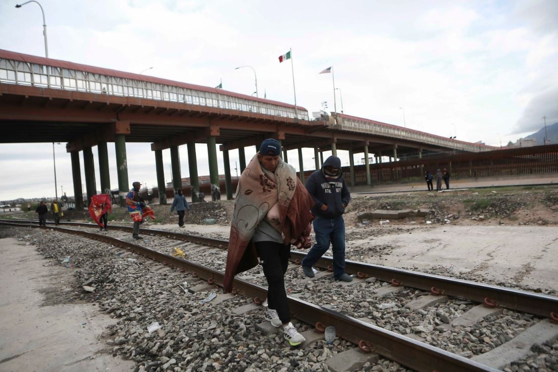 Venezuelans walk near a bridge that crosses the Rio Grande River after being expelled from the United States