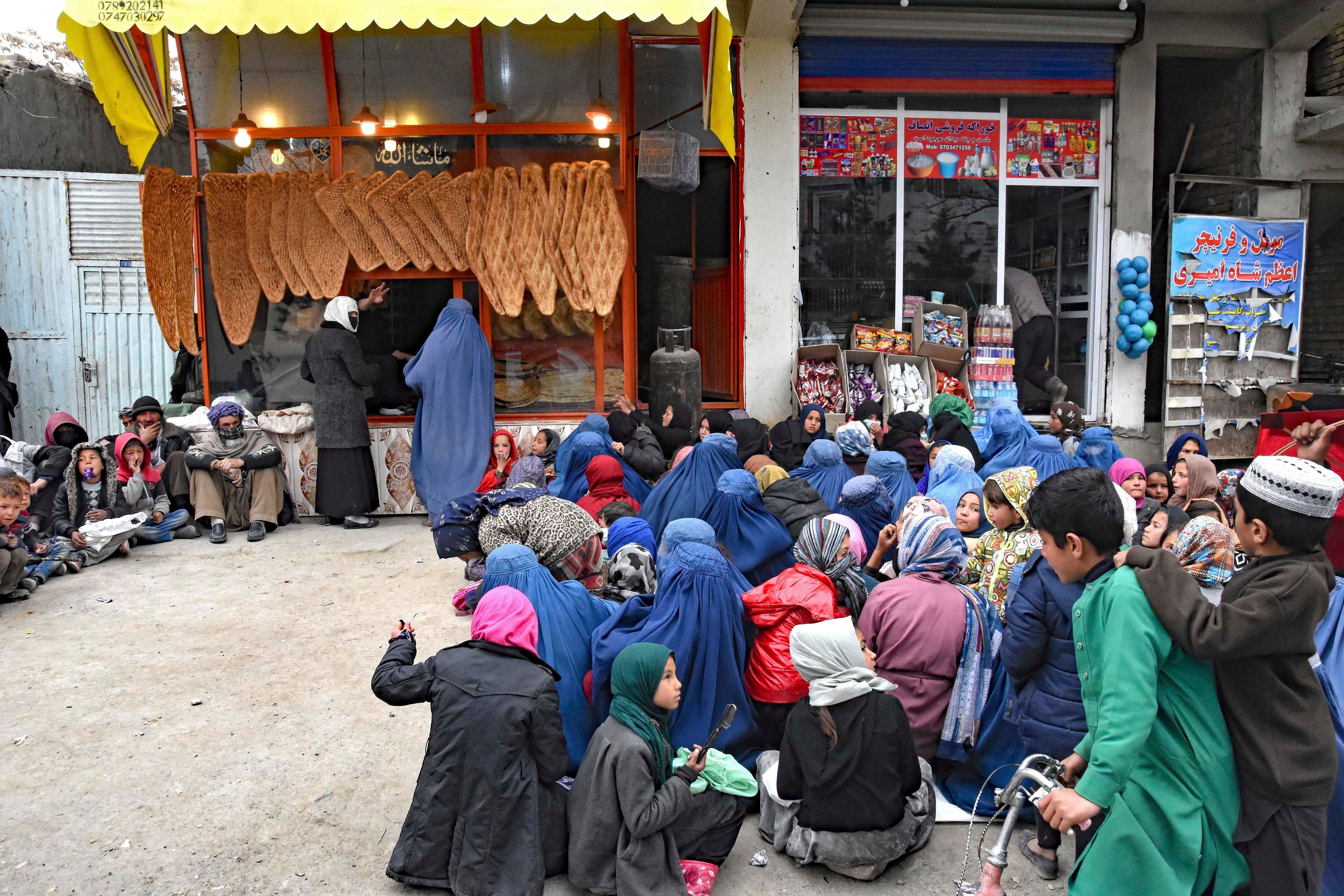 Des femmes et des enfants en attente de nourriture devant une boulangerie à Kaboul, en Afghanistan, le 28 février 2022.