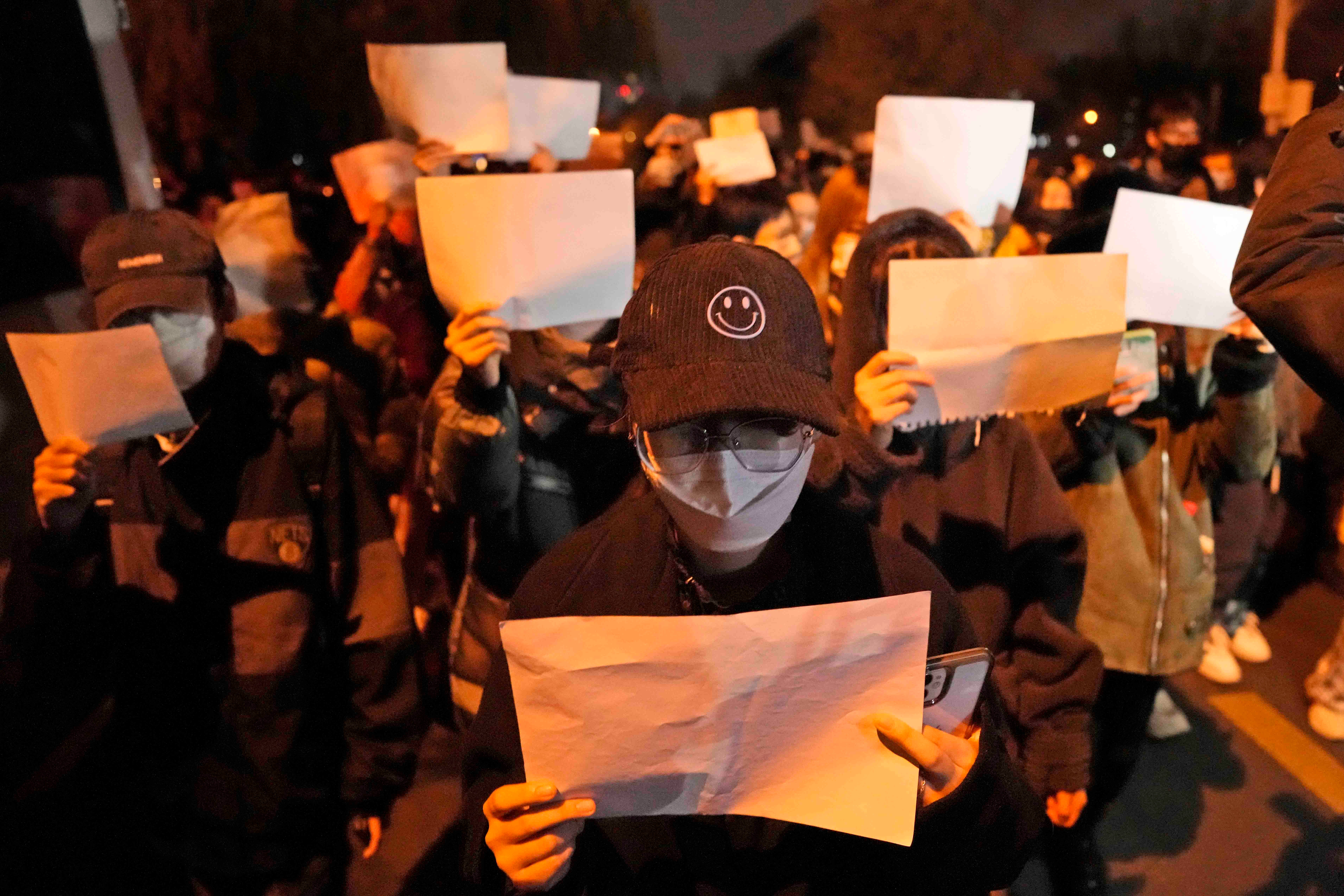 抗議民眾手持白紙上街遊行並齊呼口號，中國北京，2022年11月27日。