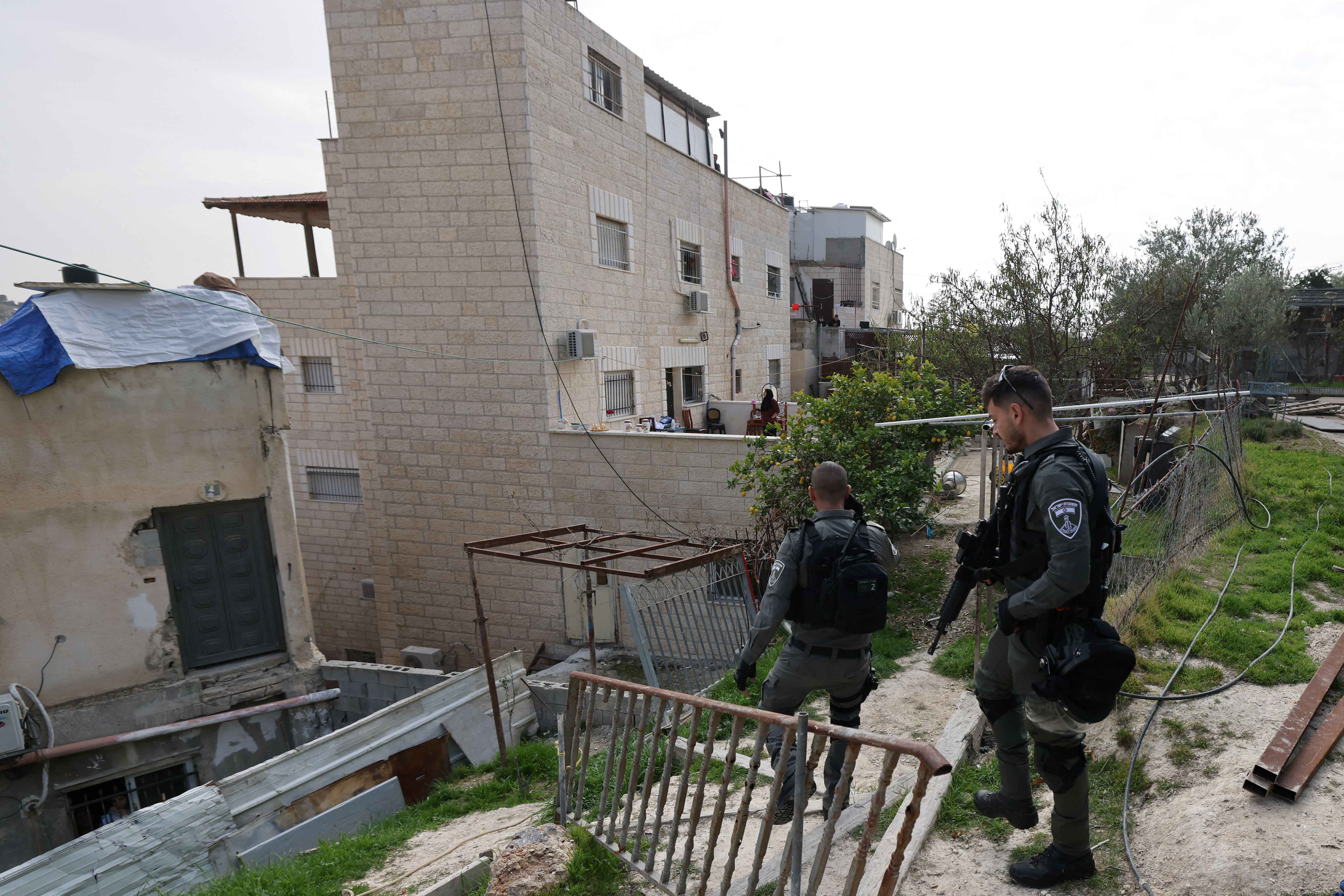 Deux membres des forces de sécurité israéliennes devant la maison de la famille de Khayri Alqam, qui a tué sept civils dans la colonie israélienne de Neve Yaakov le 27 janvier 2023. Les autorités israéliennes ont ordonné la mise sous scellés de cette maison située à Jérusalem-Est, suivie de sa démolition.