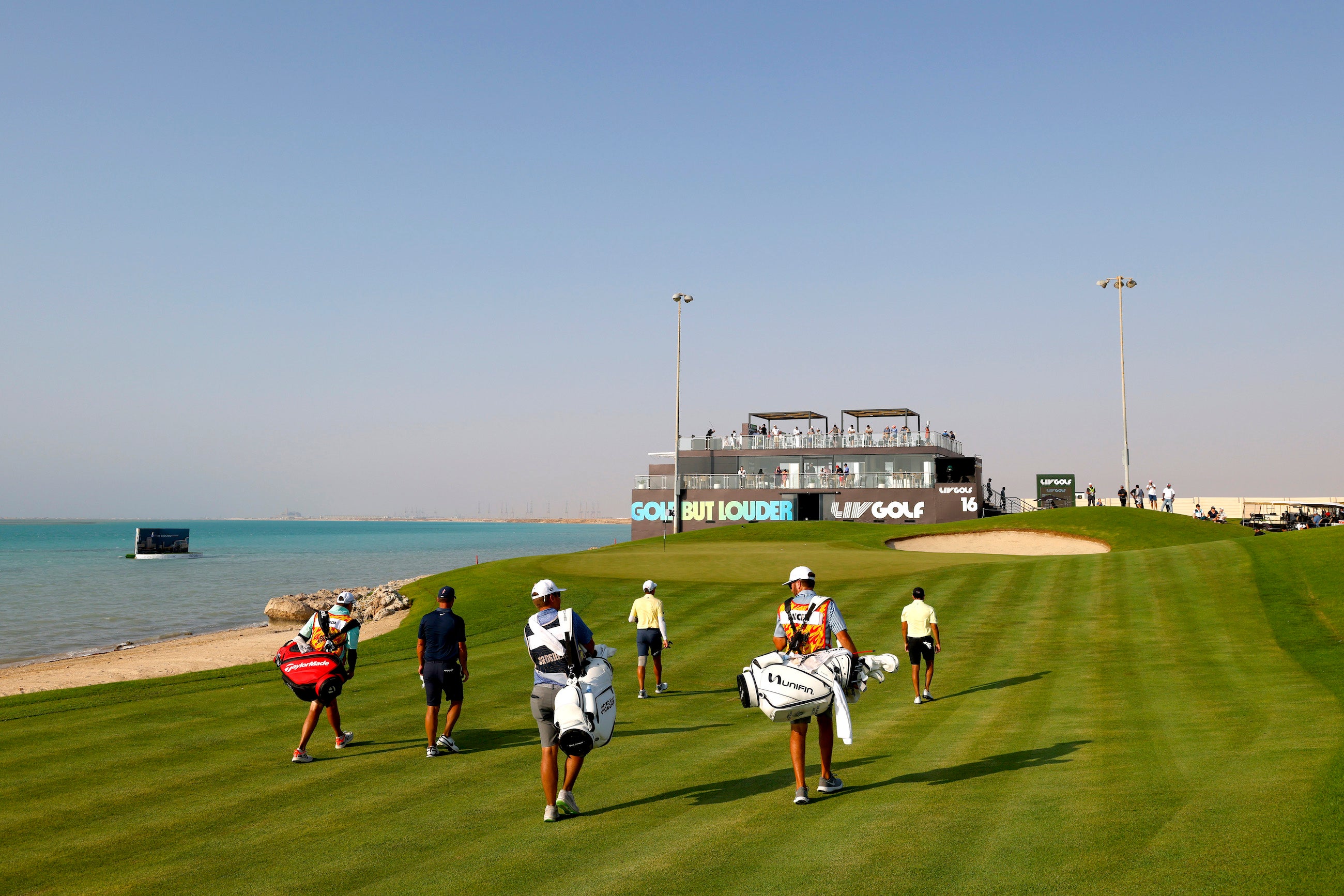 Des joueurs de golf marchent sur le 16ème trou pendant le LIV Golf Invitational au Royal Greens Golf & Country Club au King Abdullah Economic City, Arabie Saoudite, le 16 octobre 2022.