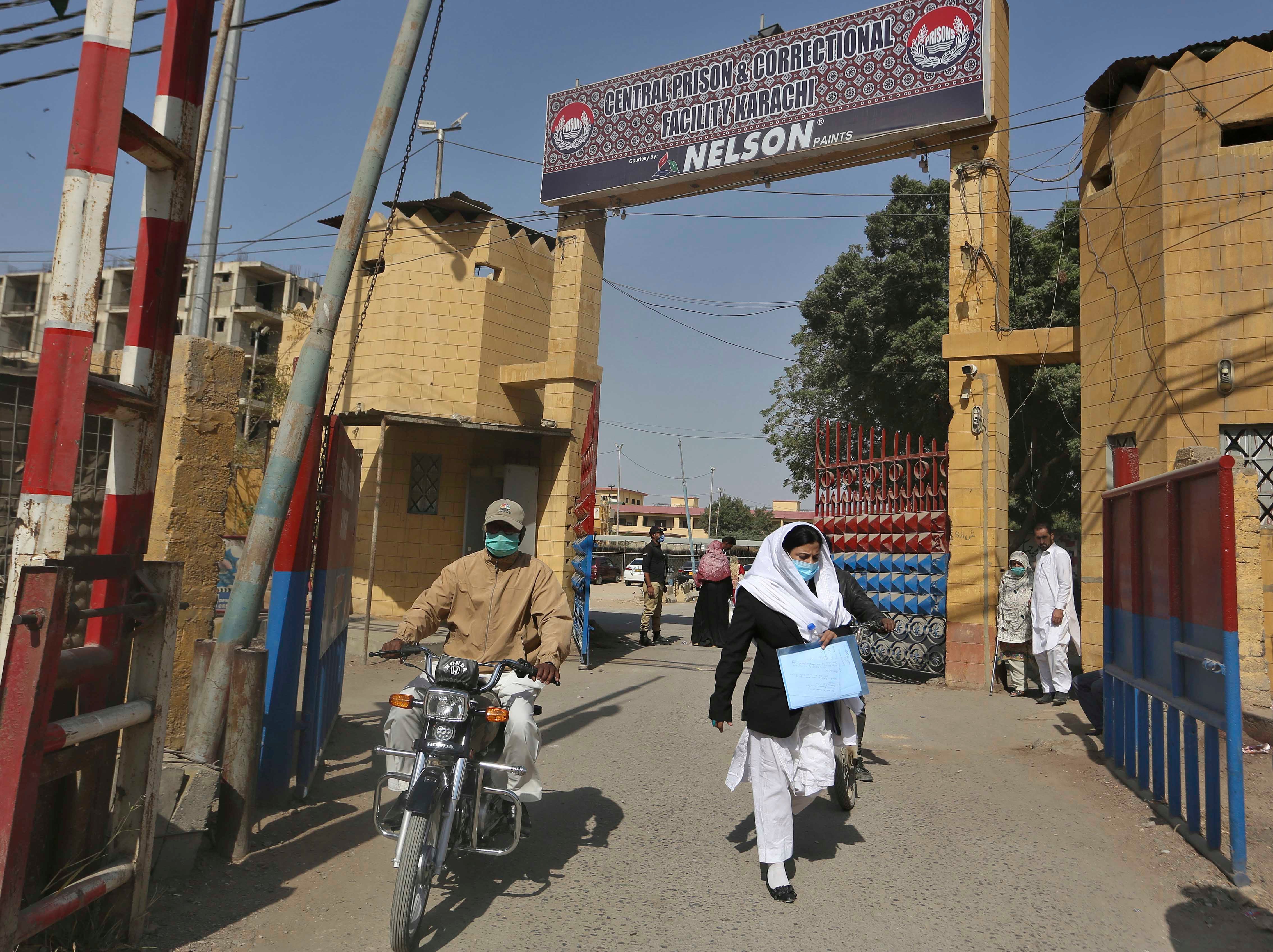 people exit the main entrance of the Karachi Central Prison