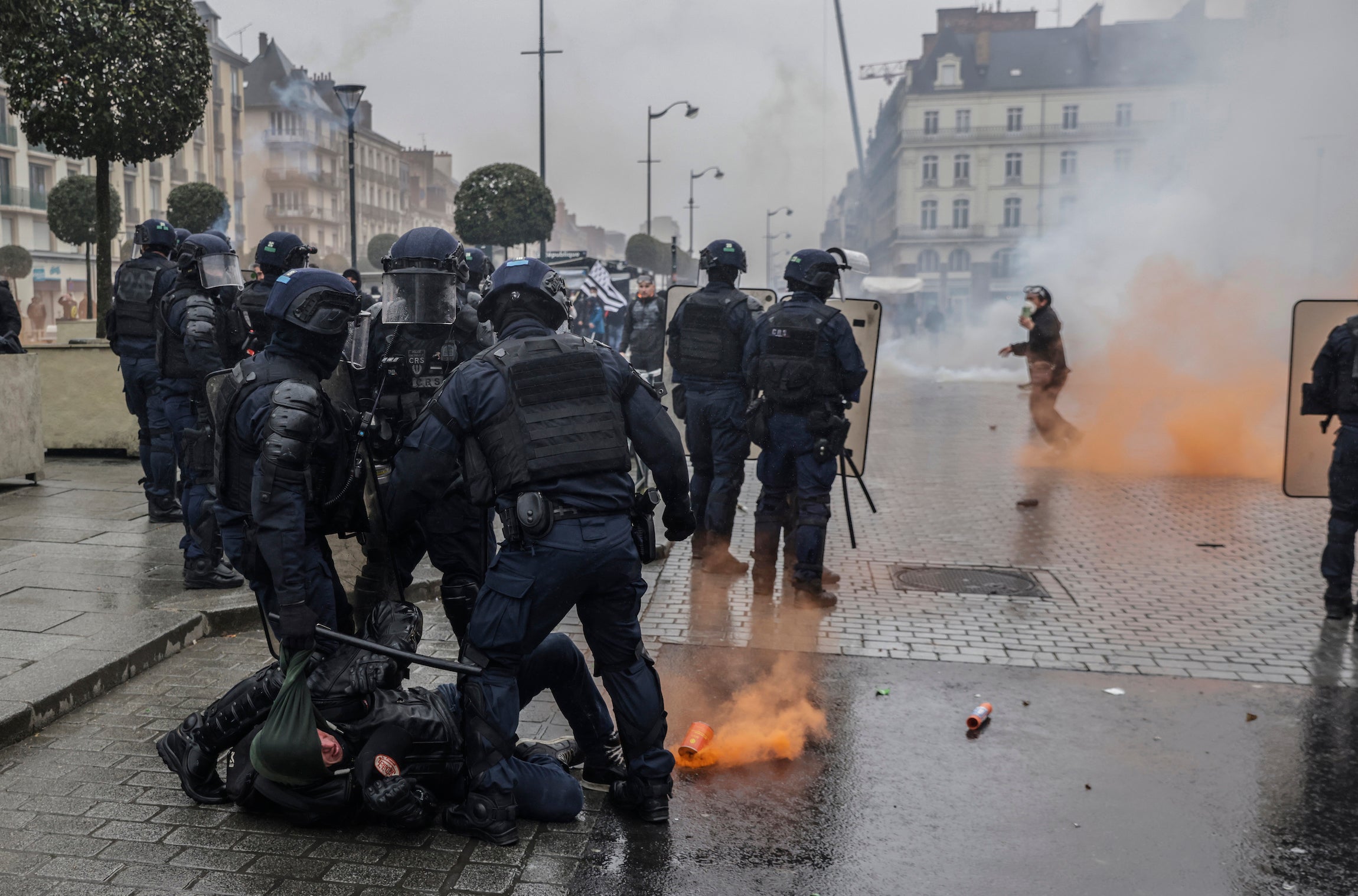 Des policiers anti-émeute immobilisent un manifestant par terre, lors d'une manifestation à Rennes, le 22 mars 2023. 