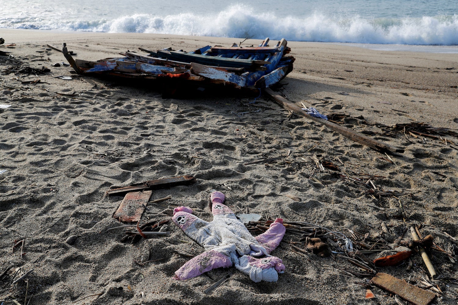 Un pezzo dell'imbarcazione e un capo di abbigliamento per bambini dal tragico naufragio di migranti a Steccato di Cutro, vicino a Crotone, Italia, 28 febbraio 2023. 