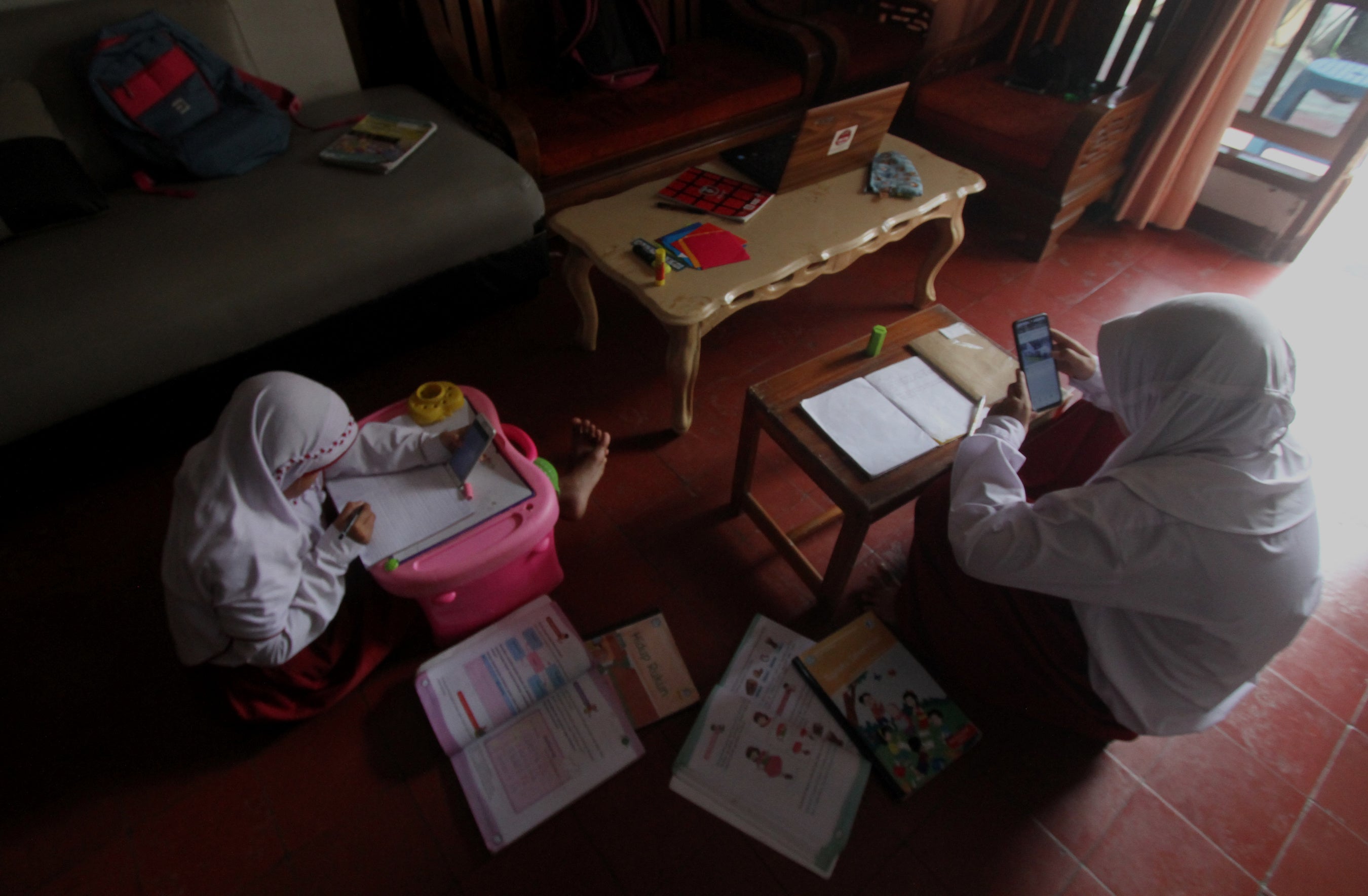 Estudiantes utilizan teléfonos móviles para realizar tareas escolares, en un sistema de aprendizaje en línea, en medio de la pandemia de coronavirus en Yakarta, Indonesia. 21 de julio de 2020.