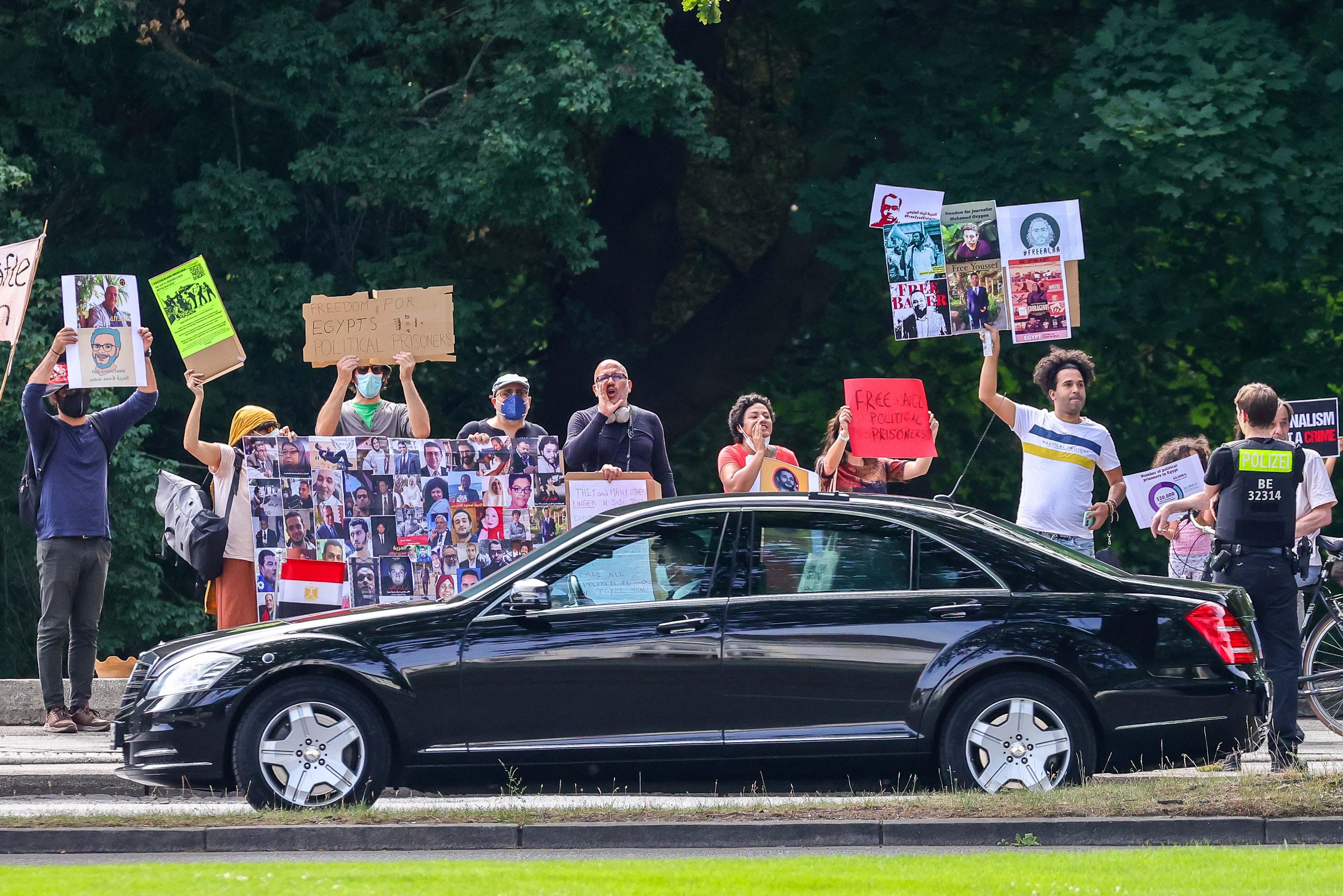محتجون يحملون لافتات يهتفون خلال زيارة الرئيس المصري عبد الفتاح السيسي إلى ألمانيا في 18 يوليو/تموز 2022 في برلين.