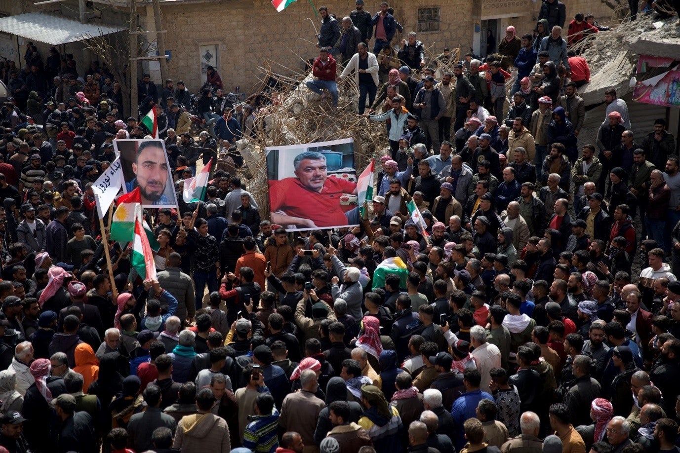 Syrian Kurds hold up pictures of two of the victims killed at the hands of Turkish-backed fighters during protests in Jinderis. 
