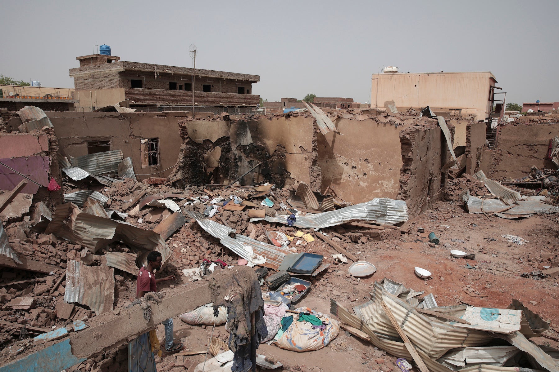 A man walks by a house hit in recent fighting in Khartoum, Sudan.