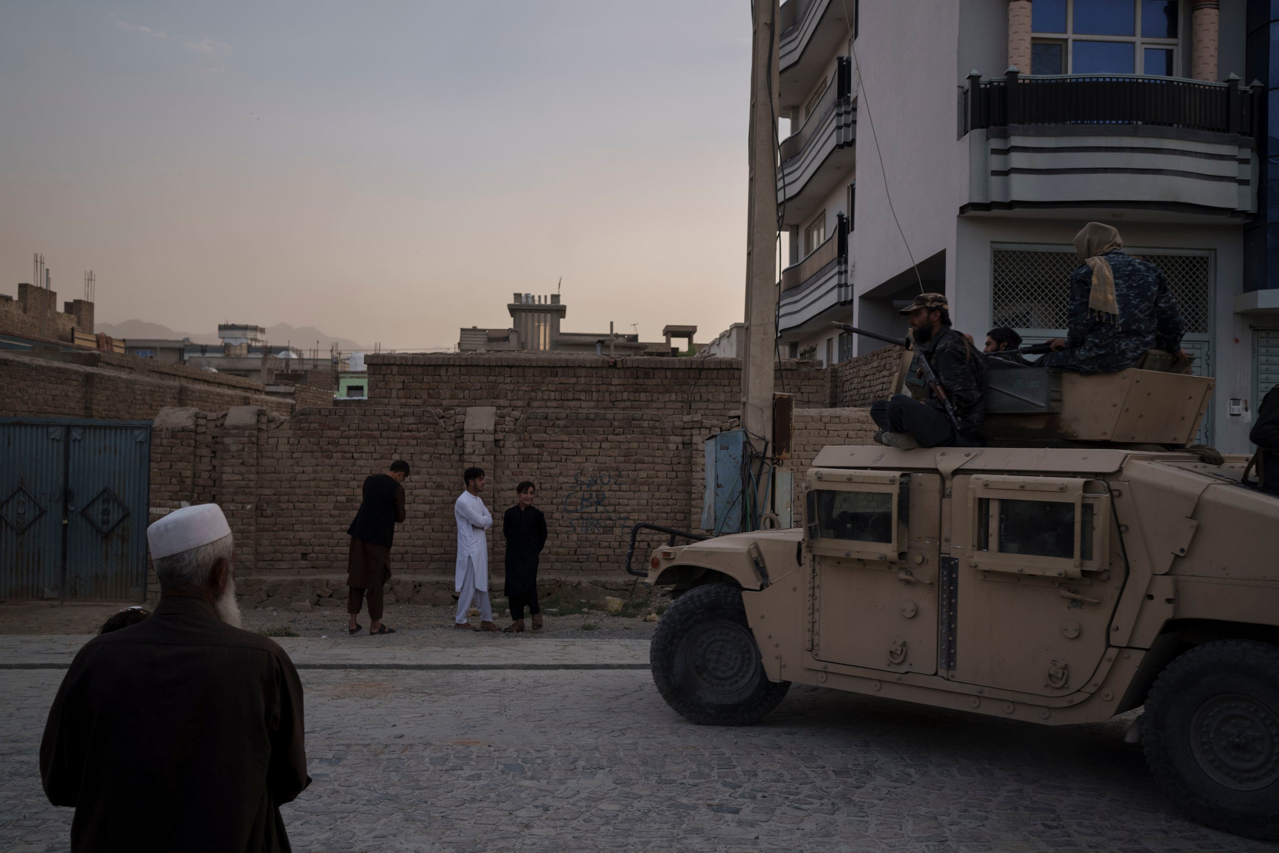 Taliban fighters ride atop a Humvee after detaining four men in Kabul, Afghanistan.