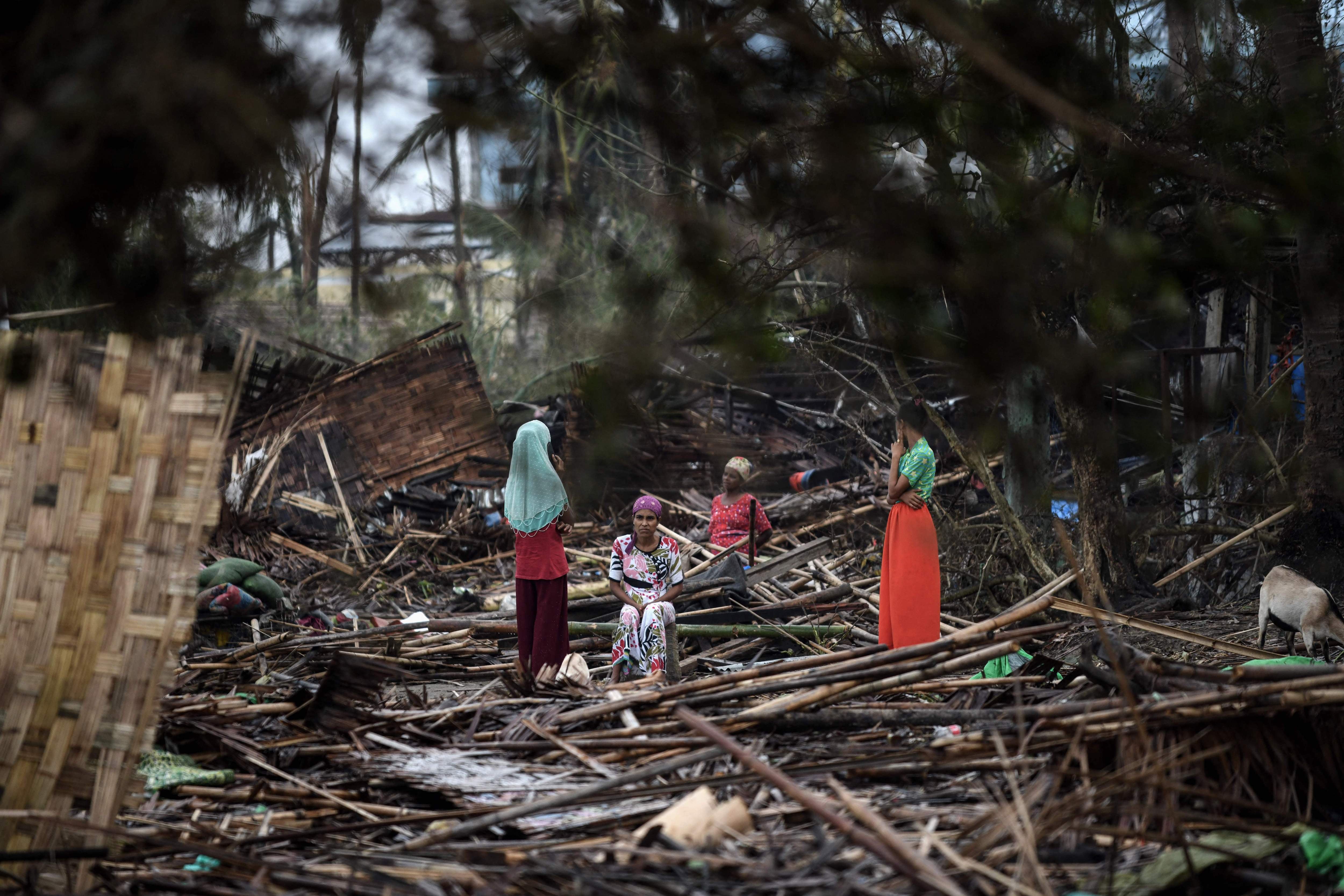 Des femmes rohingyas, photographiées le 16 mai 2023 parmi les décombres de leur abri dans le camp de Basara à Sittwe, capitale de l’État de Rakhine dans l’ouest du Myanmar ; cette région a été durement touchée par le cyclone Mocha.