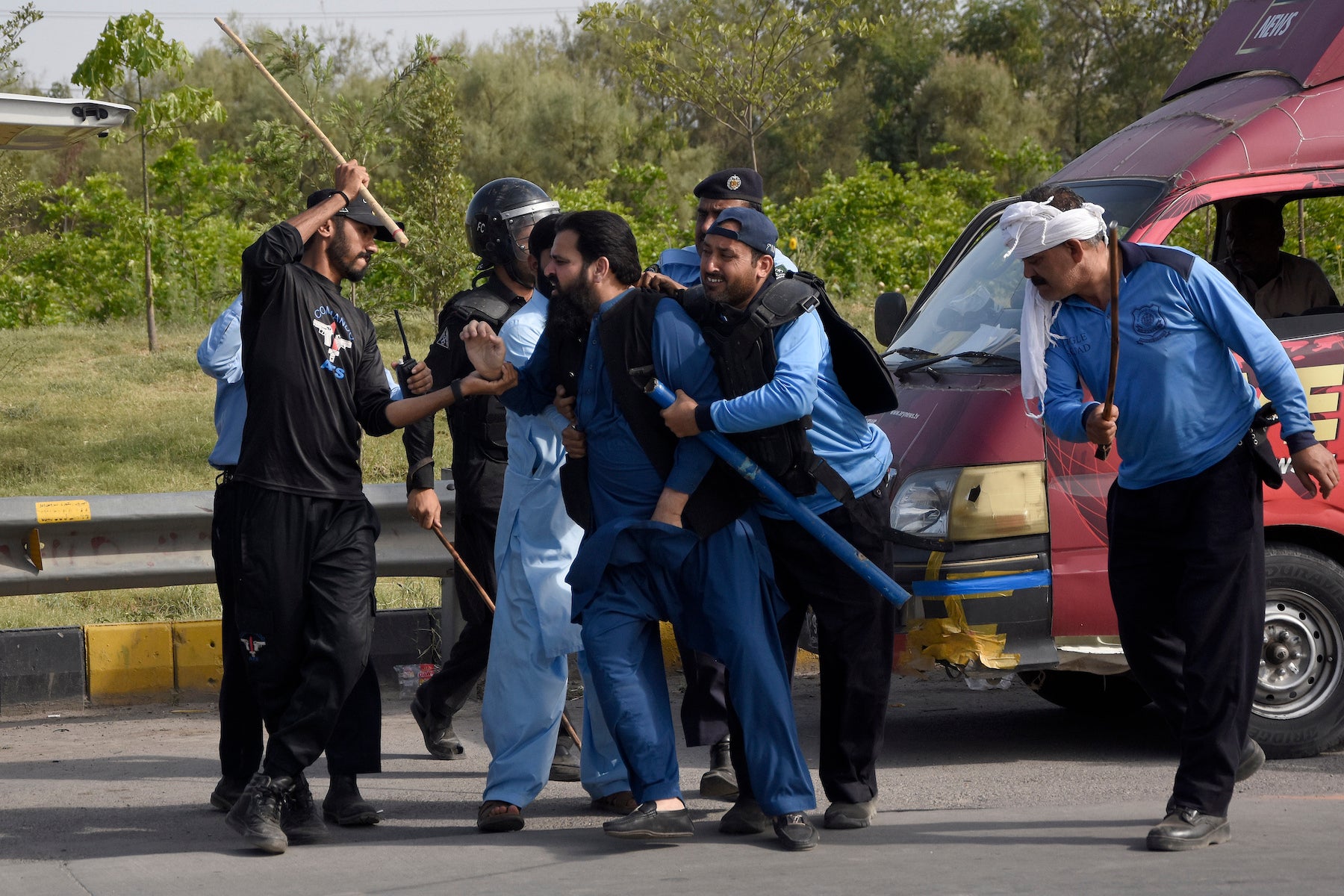 Police detain a supporter of Pakistan's former Prime Minister Imran Khan during clashes, in Islamabad, Pakistan.