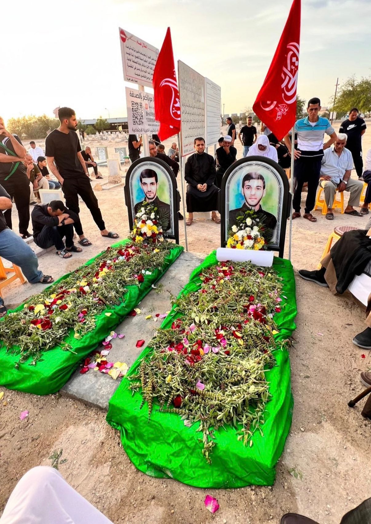 أشخاص يتجمعون أمام القبرين الرمزيين لجعفر سلطان (يسار) وصادق ثامر، في البحرين. 