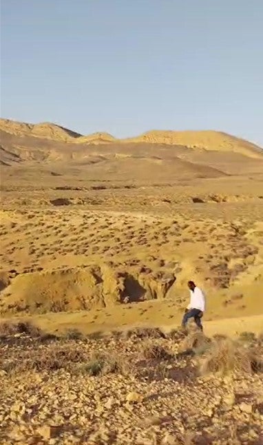 A man walks in the desert near the Tunisia-Algeria border between July 5 and 7, 2023, after groups of Black African migrants and asylum seekers were collectively expelled or forcibly transferred there from Sfax, Tunisia, by Tunisian security forces. © 2023 Private