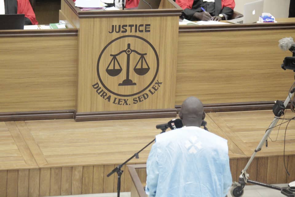 A man stands in front of a judge