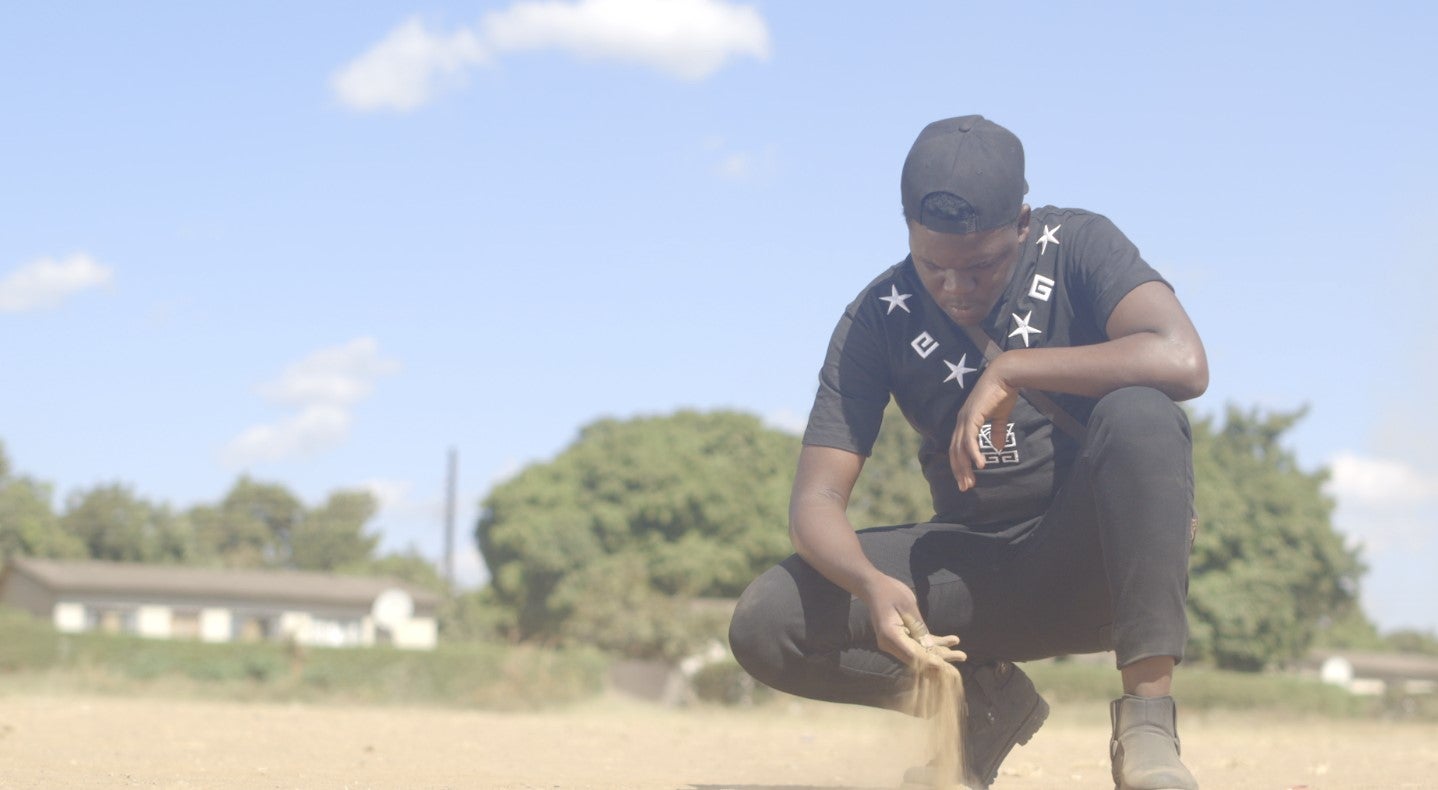 Un militant écologiste examine le sol dans le township de Chowa, à Kabwe, en Zambie. Cette ville affiche un taux élevé de contamination au plomb. 