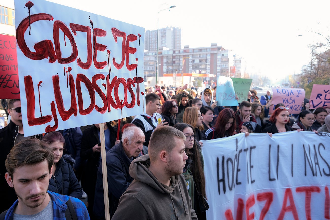 A man holds a banner that reads "Where is Humanity" during a protest following the release of disturbing photos from the Pazaric care home, Sarajevo, Bosnia, November 22, 2019. 