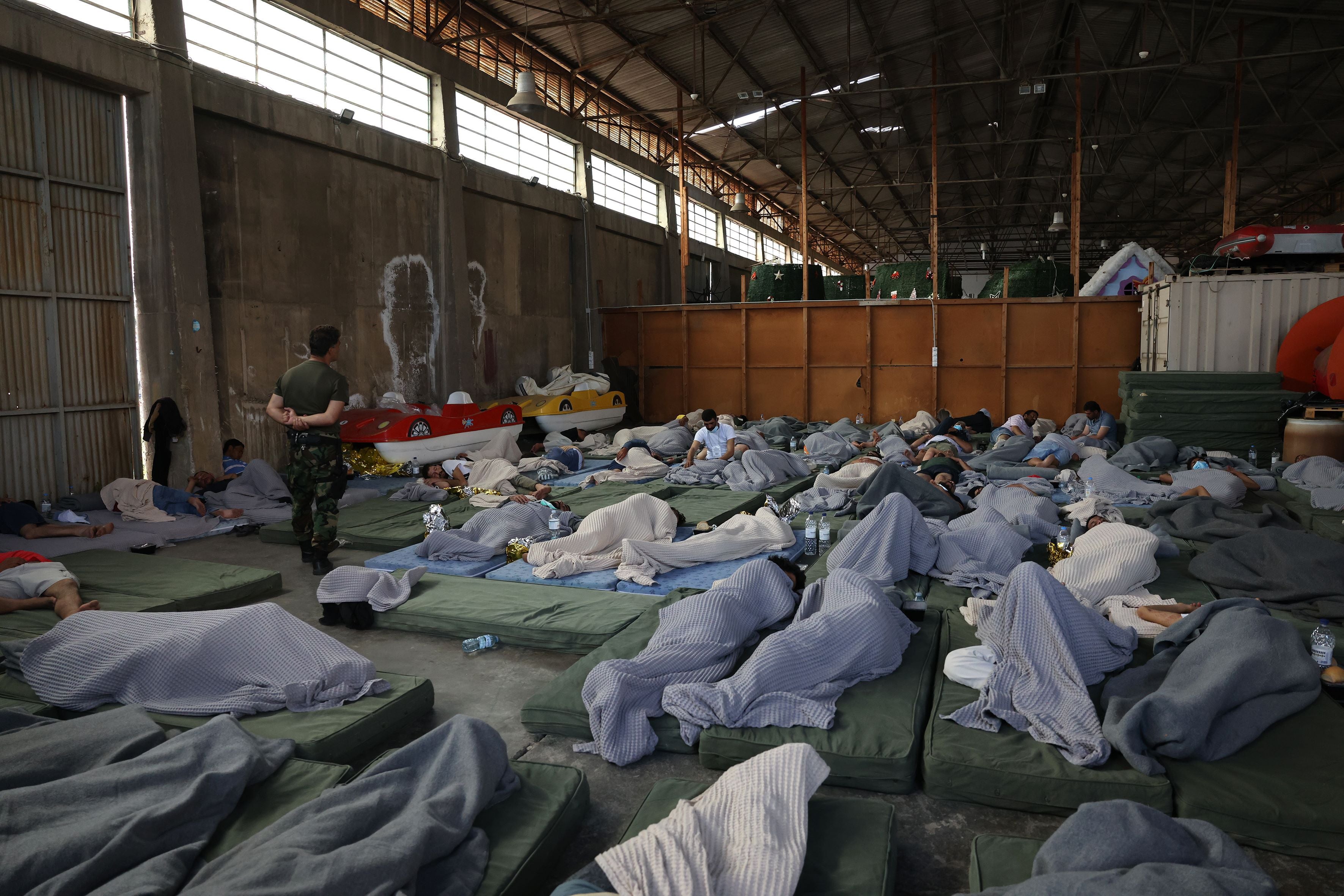 Des migrants secourus s'abritent dans un dépôt après un naufrage au large de Kalamata, en Grèce, le 14 juin 2023. 2023 Costas Baltas/Anadolu Agency via Getty Images © 2023 Costas Baltas/Anadolu Agency via Getty Images