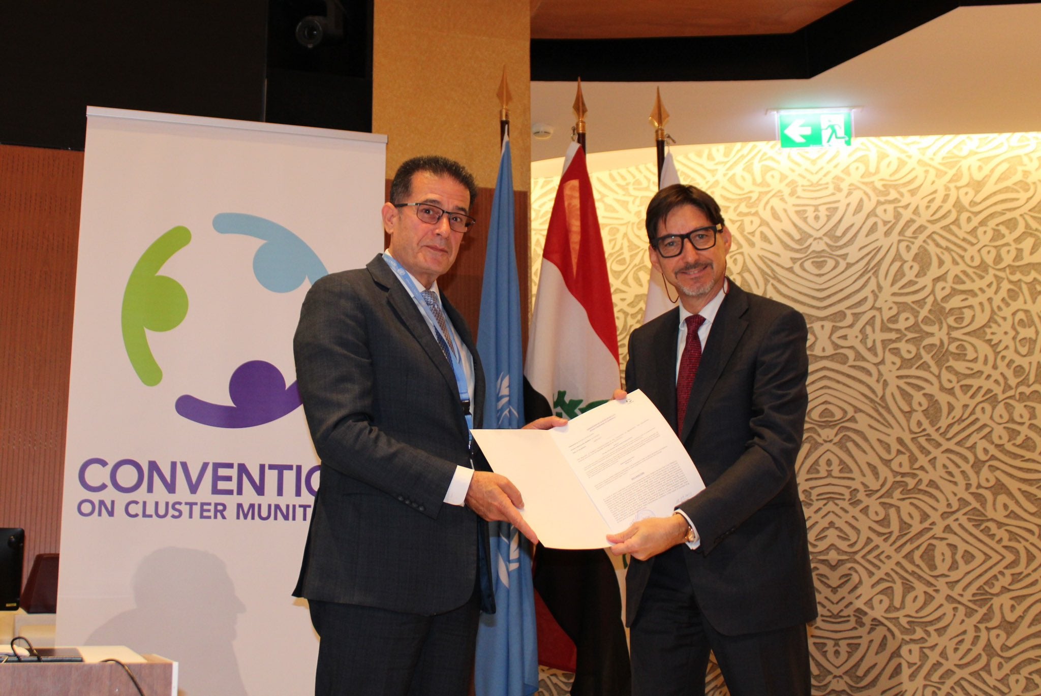 Amb. Yuri Sterk of Bulgaria (right) hands over formal documents confirming his country’s completion of the destruction of its stockpile of 6,862 cluster munitions and 186,349 submunitions to the president of the Convention on Cluster Munitions, Amb. Abdul Karim Hashim Mustafa of Iraq, September 12, 2023. 