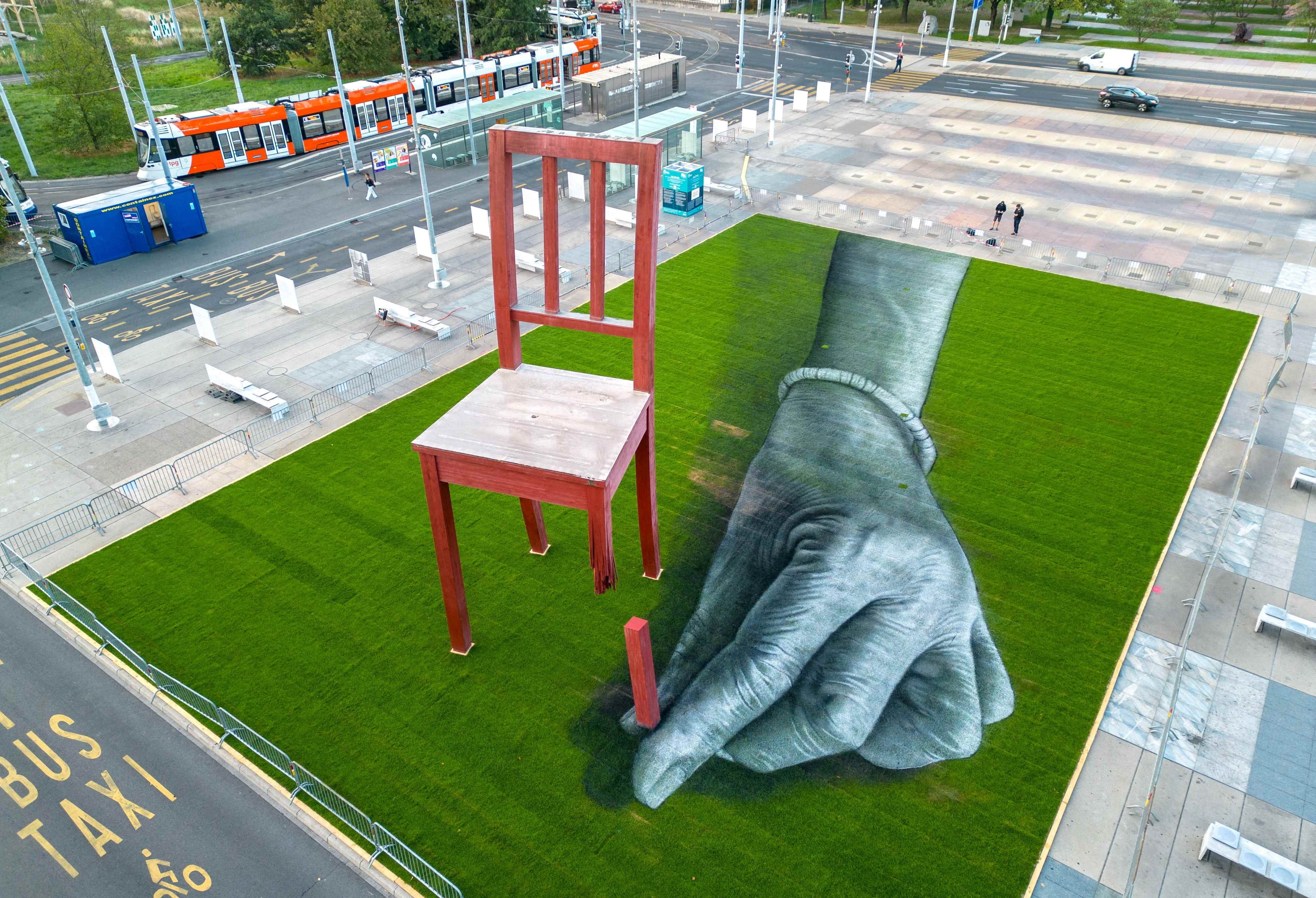 A land art painting called "All of us!" by the artist Saype in front of the United Nations headquarters in Geneva installed during a meeting of the Convention on Cluster Munitions, September 11, 2023. 
